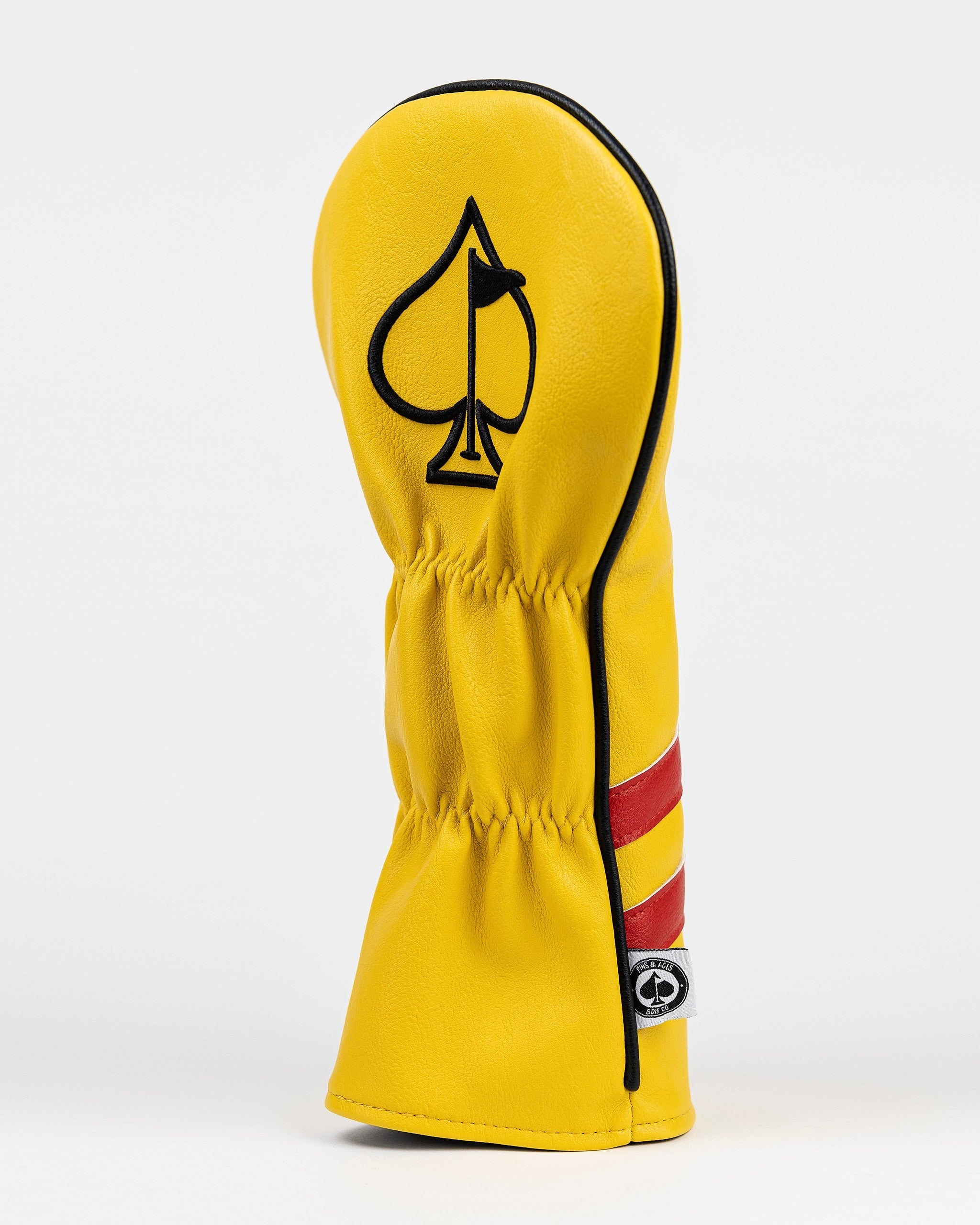 Bold yellow driver cover featuring a black spade logo and red stripes, designed for golfers who want to stand out.