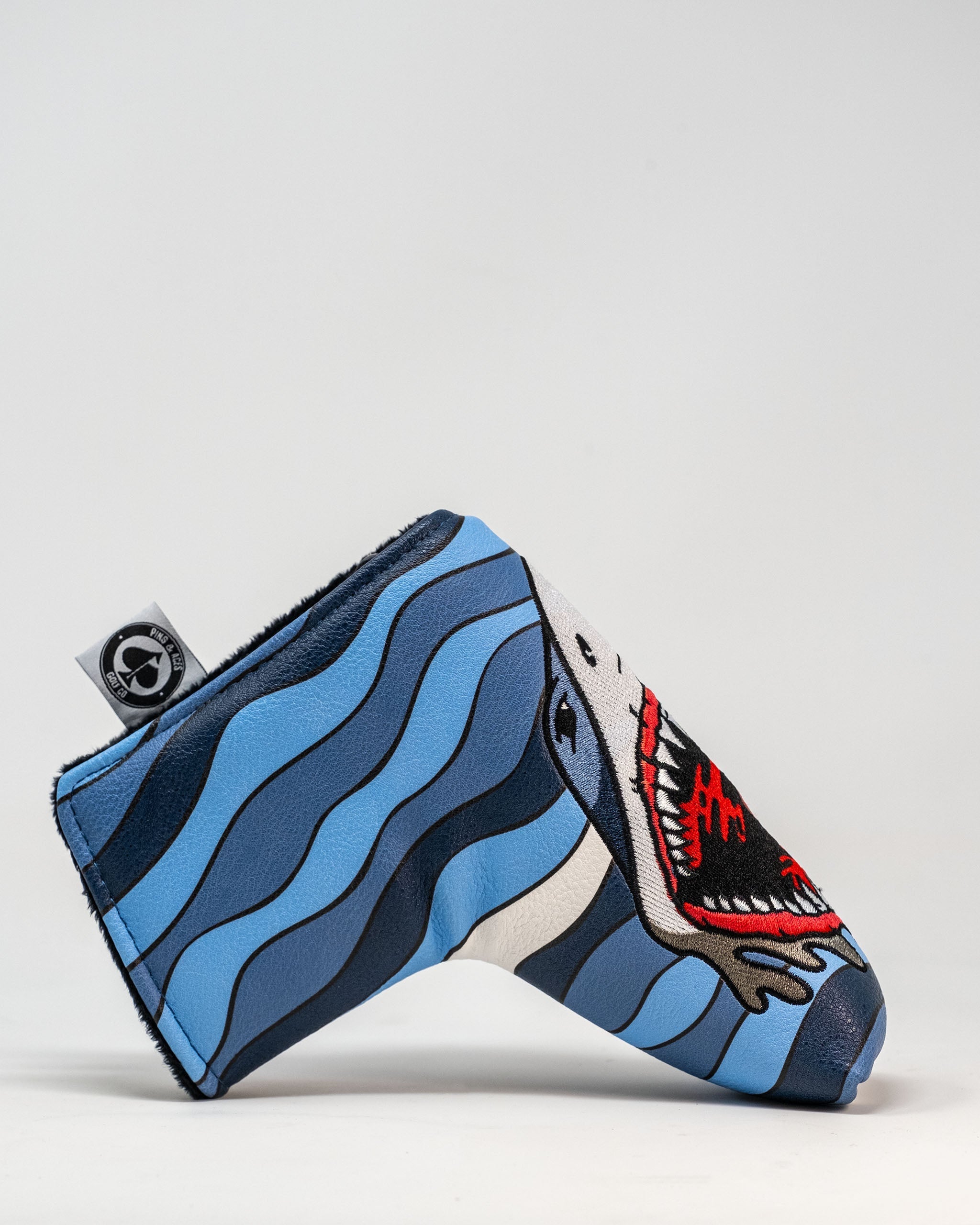 Bold Shark Attack blade putter cover featuring a fierce shark design against blue waves, perfect for standout golfers.