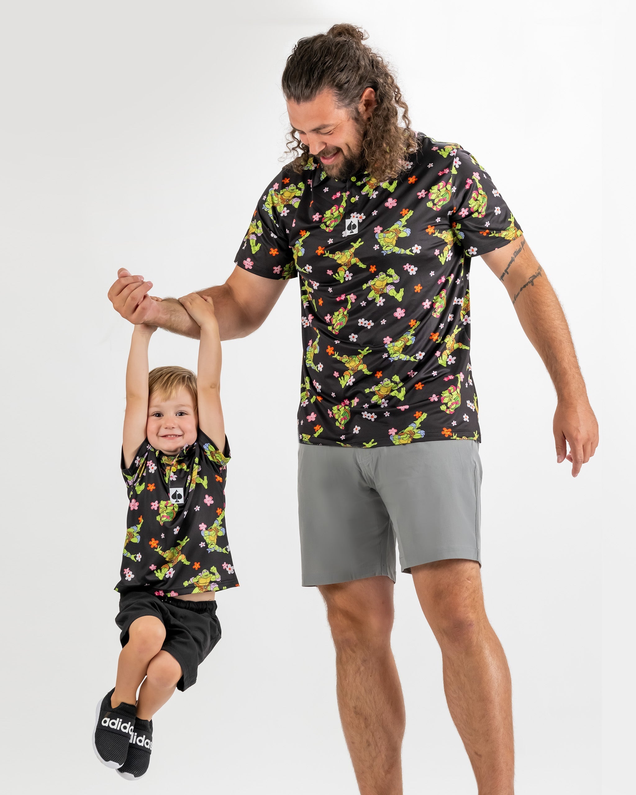 Youth Turtle Flower Power shirt featuring vibrant TMNT designs, worn by a child and adult, showcasing playful style.