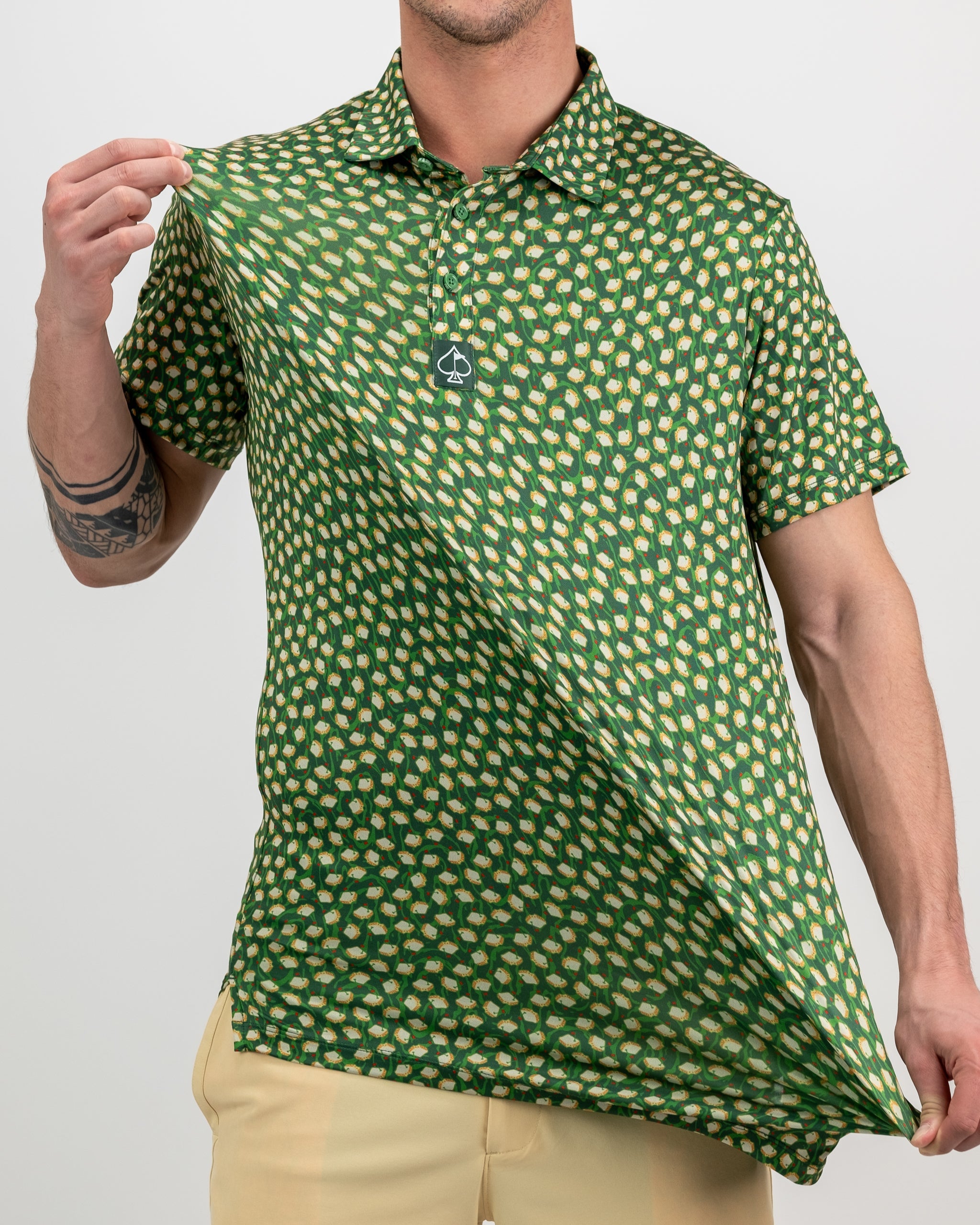 Green golf polo shirt with a bold, repeated golf ball pattern and a spade logo tag on the chest.