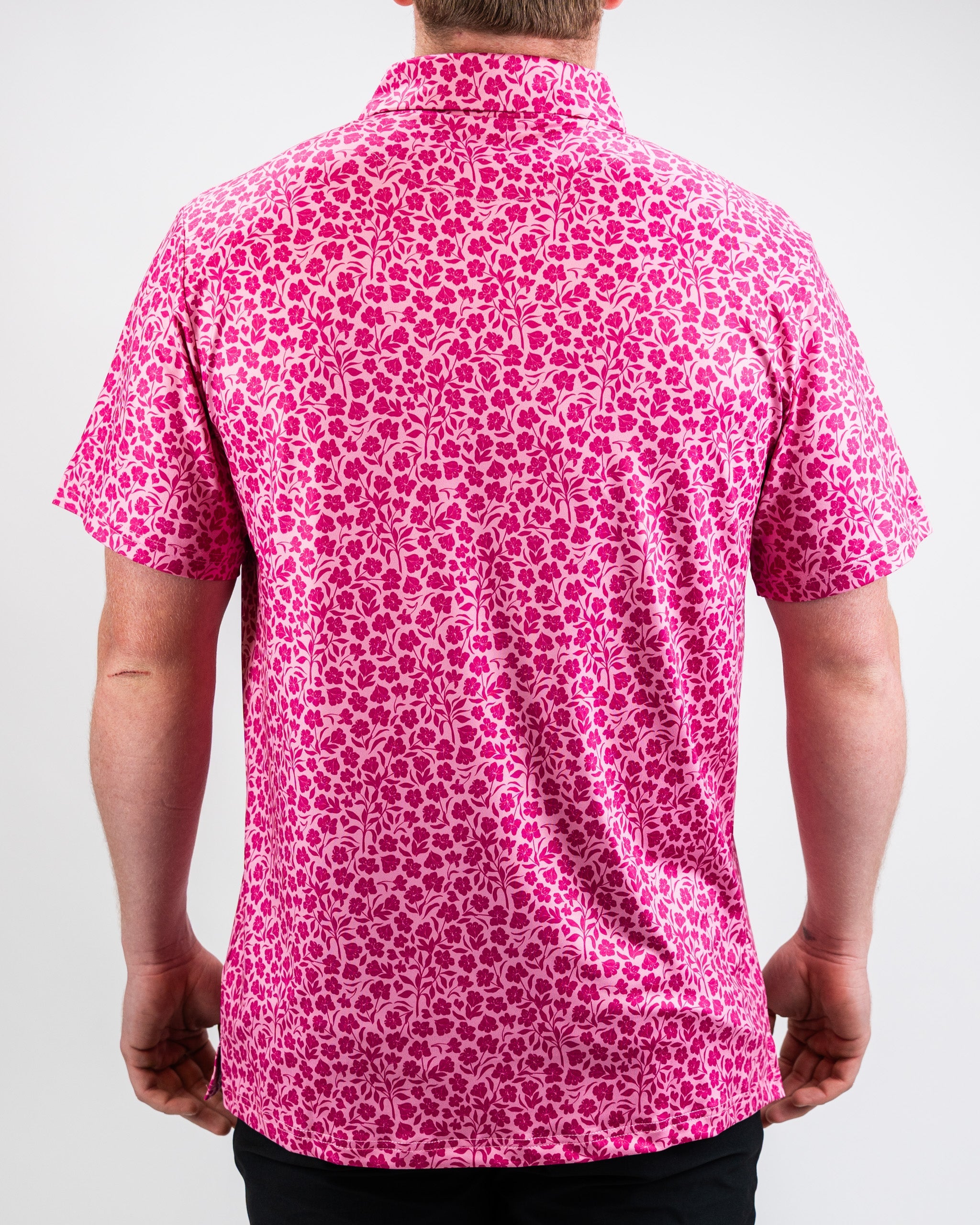 Pink hibiscus flower with vibrant petals set against a neutral background.