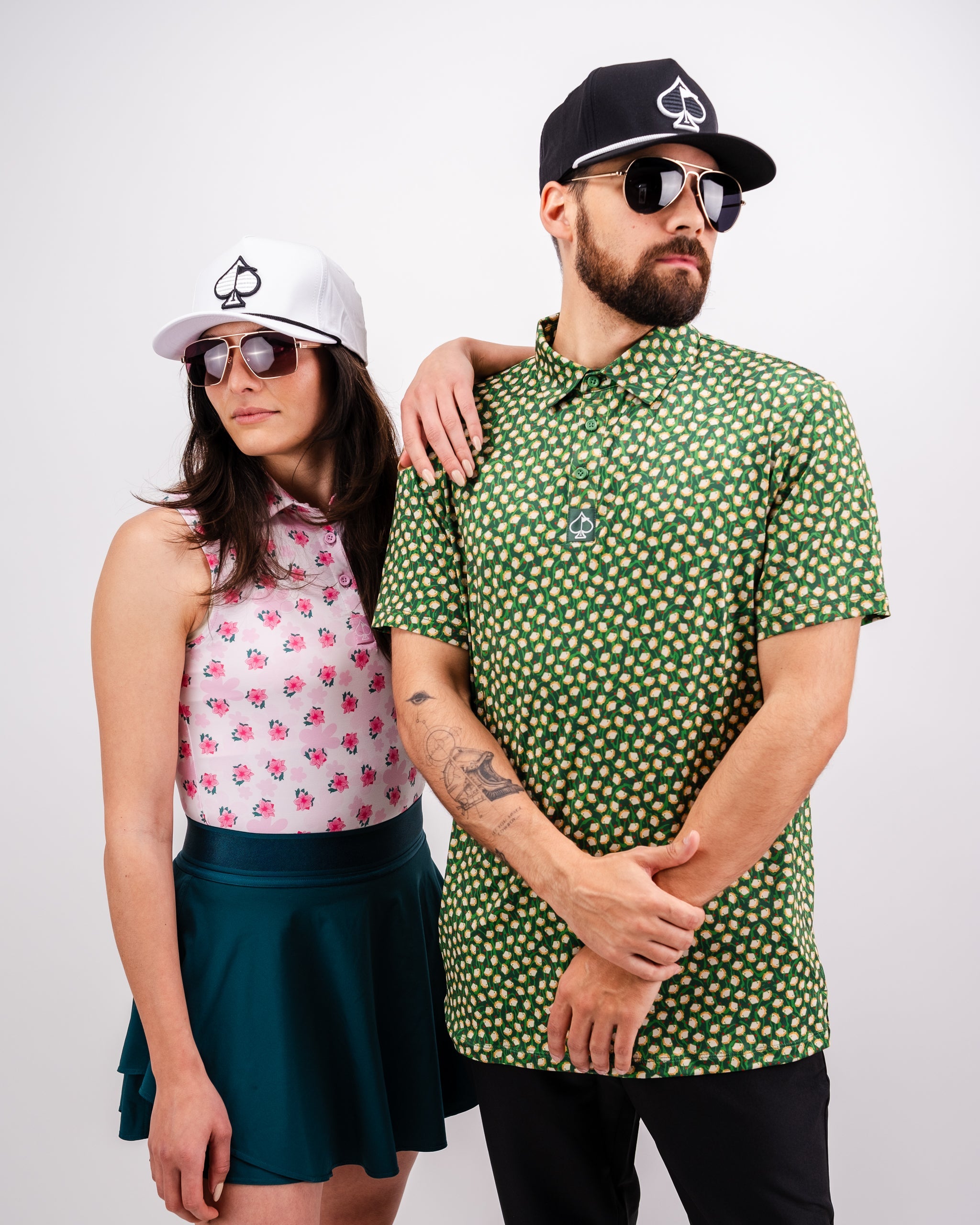 Stylish golfers in bold print shirts, black and white caps with spade logos, and sunglasses for a standout look on the cou...