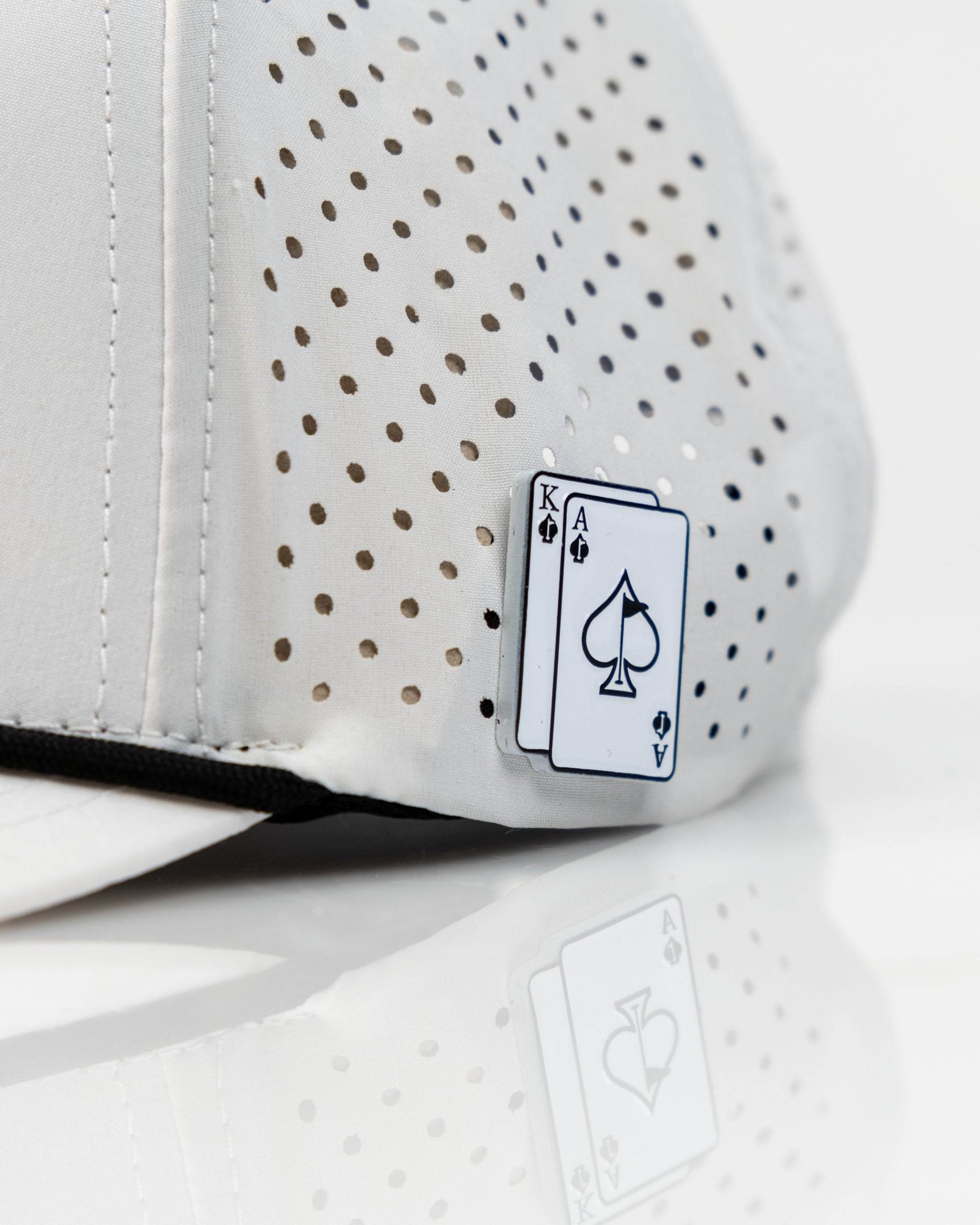 White perforated rope hat featuring an Ace and King playing card design, perfect for stylish golfers.