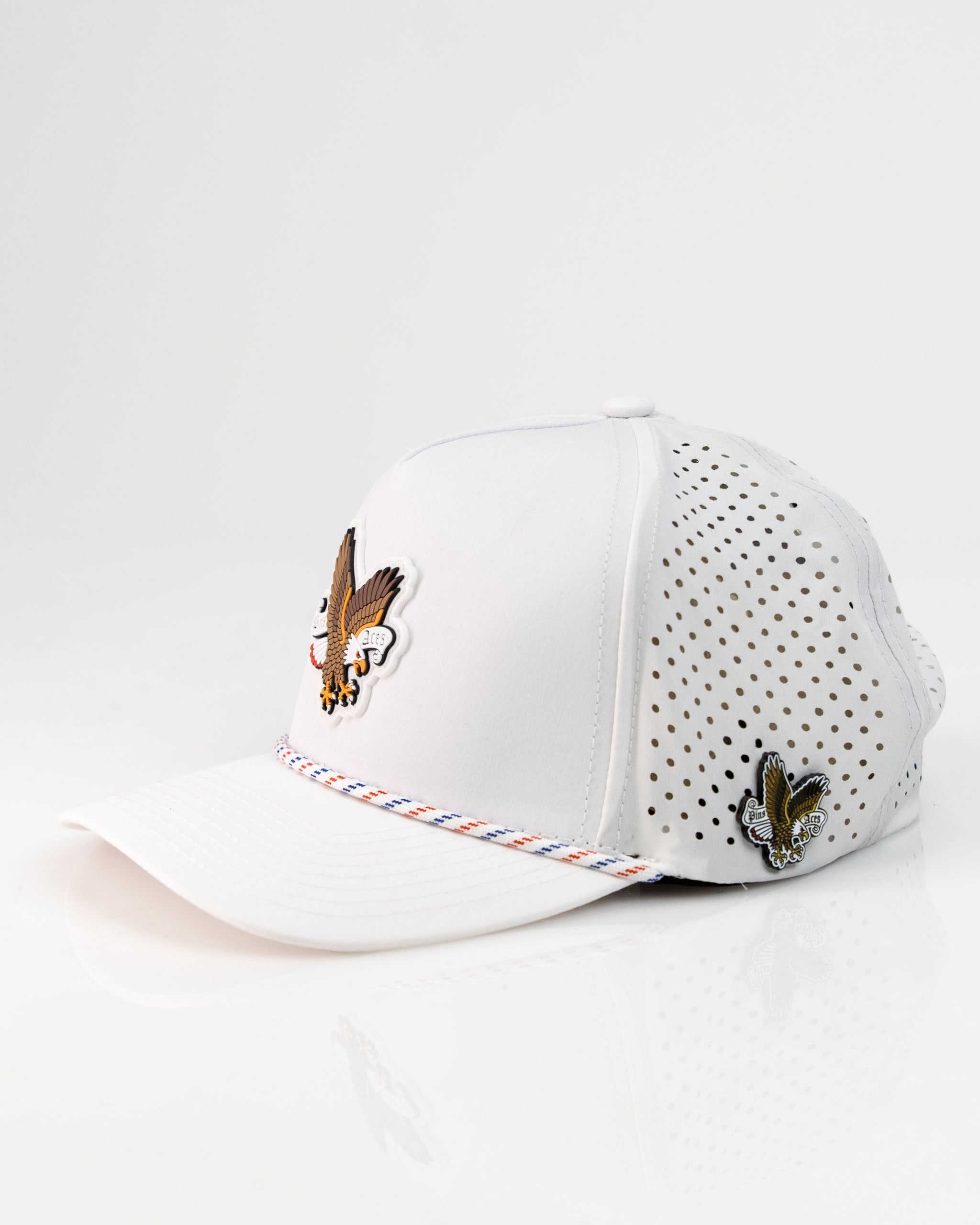 White perforated rope hat featuring an eagle design and colorful detailing, perfect for stylish golfers.