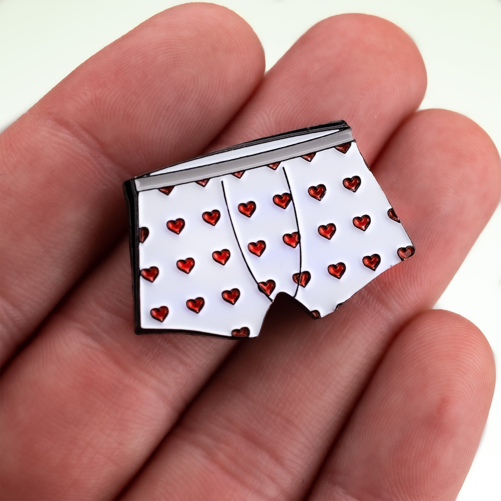 Heart Boxers Ball Marker held in hand, featuring a colorful design with heart patterns.
