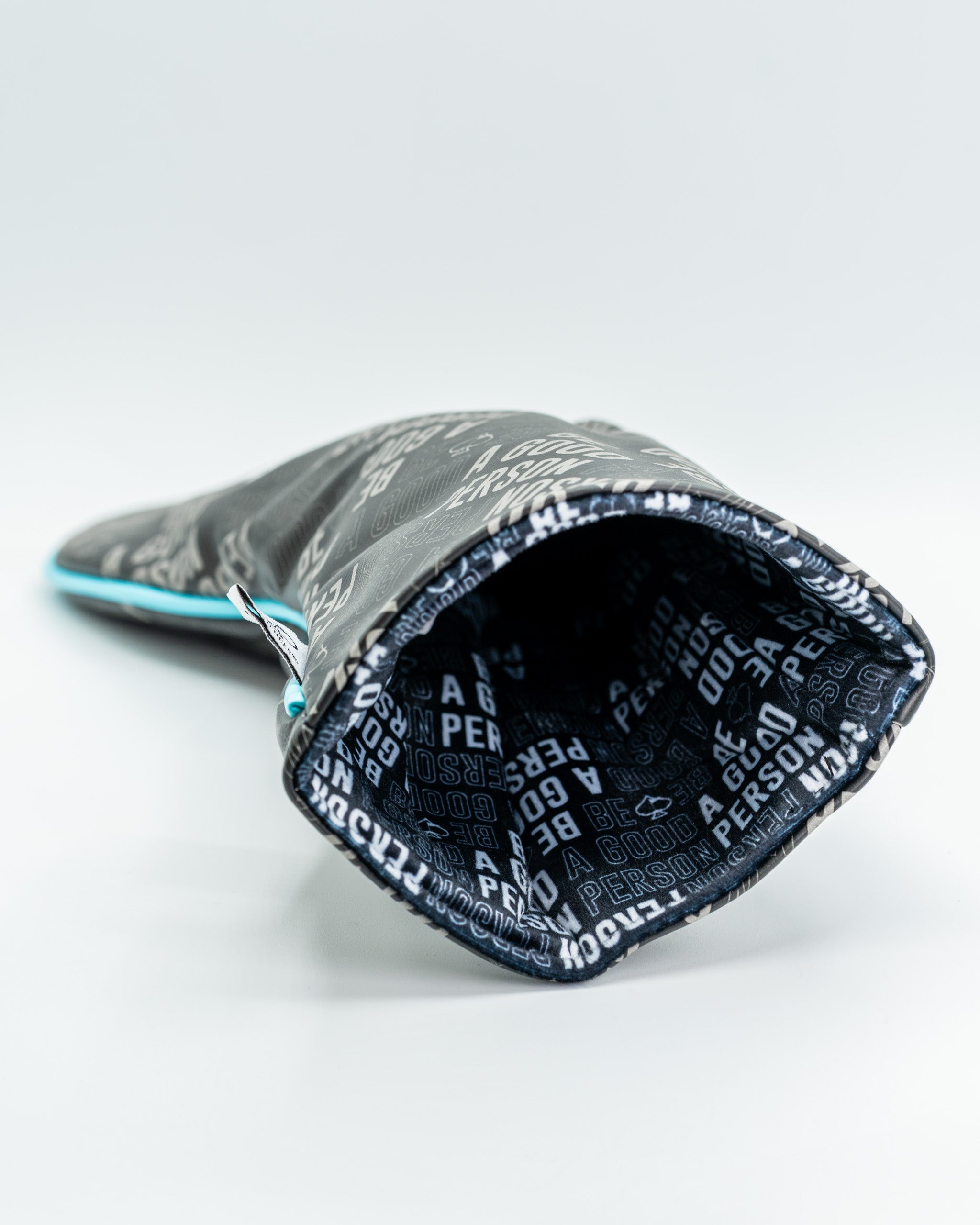 Black driver cover featuring a bold "Be A Good Person" design, showcasing a stylish interior with repeating text pattern.