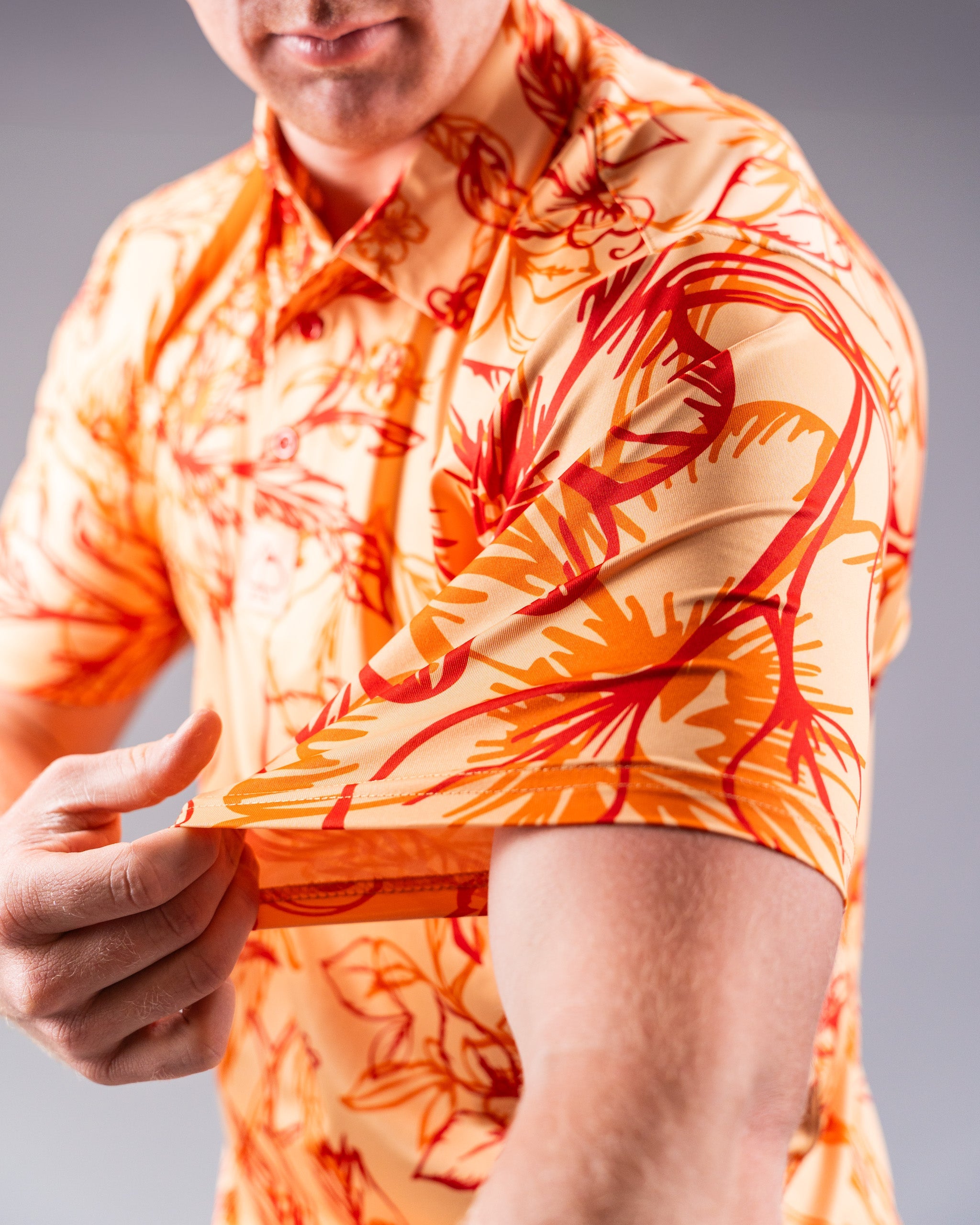 Men's Cabo Sunburst polo shirt in vibrant orange and yellow gradient design, featuring a classic collar and short sleeves.