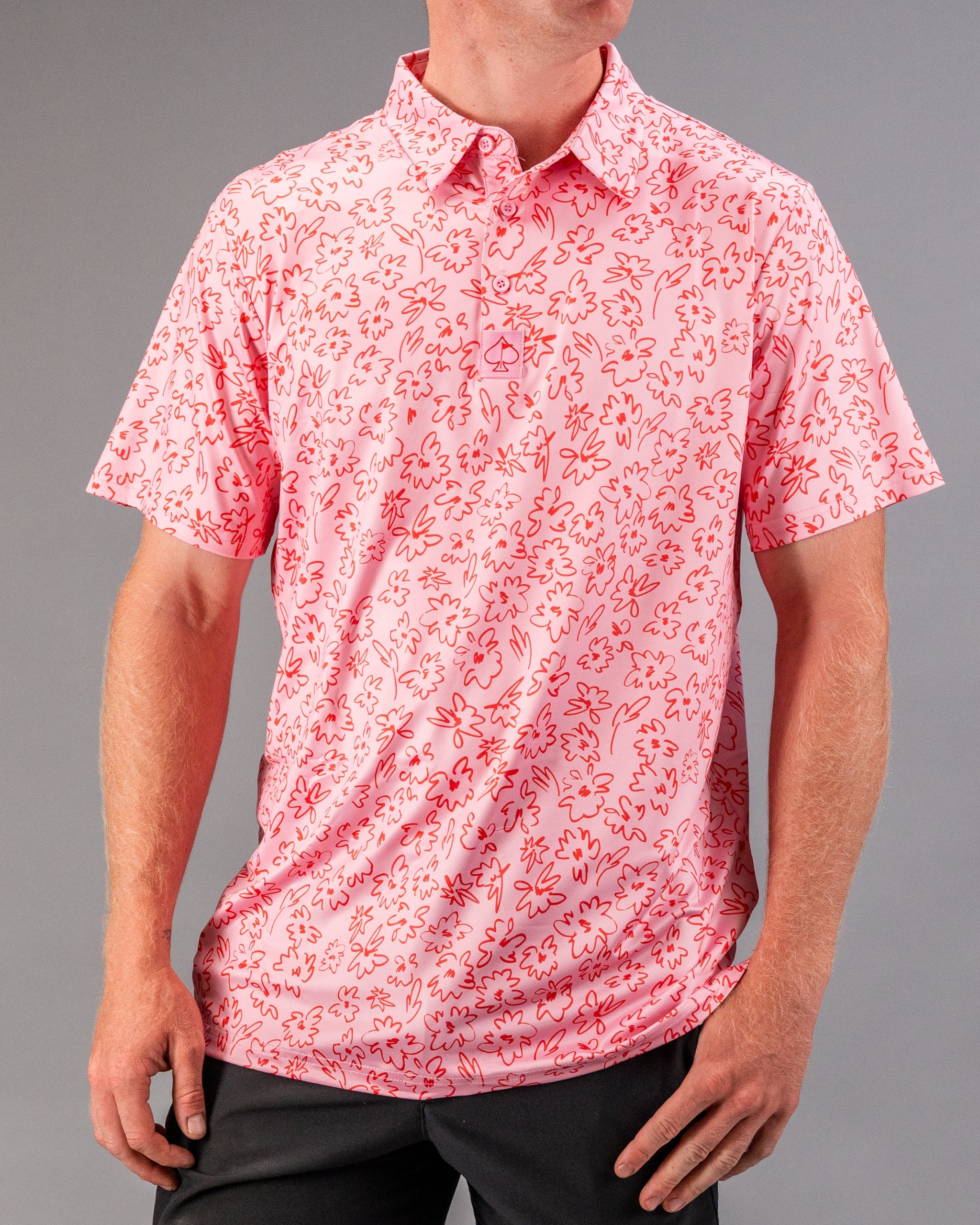 Men's short-sleeve golf shirt in pink with a vibrant flower doodle pattern, perfect for stylish play on the course.