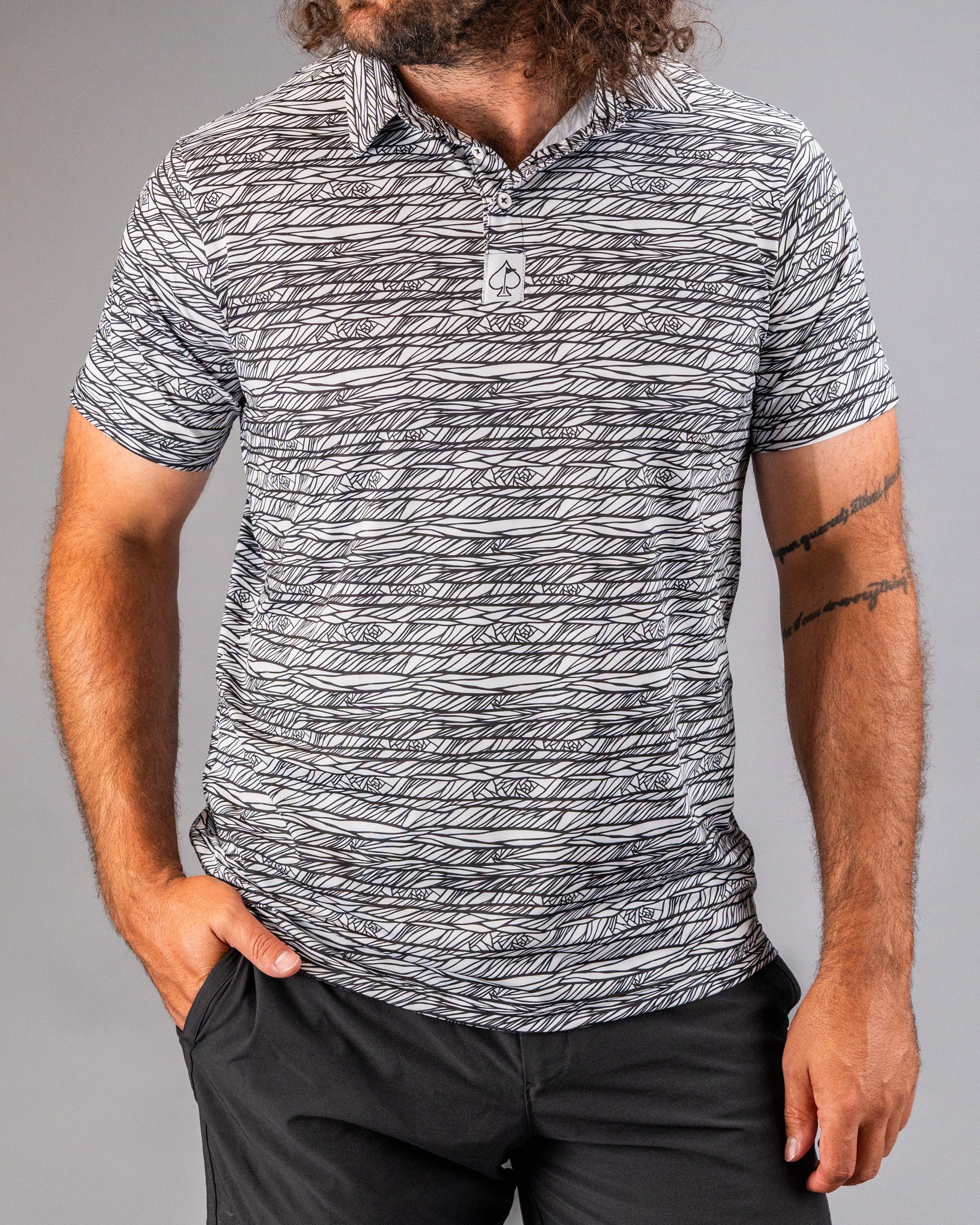 Men's Fragment Black golf polo featuring a bold, abstract pattern in black and white, perfect for stylish performance on the course.