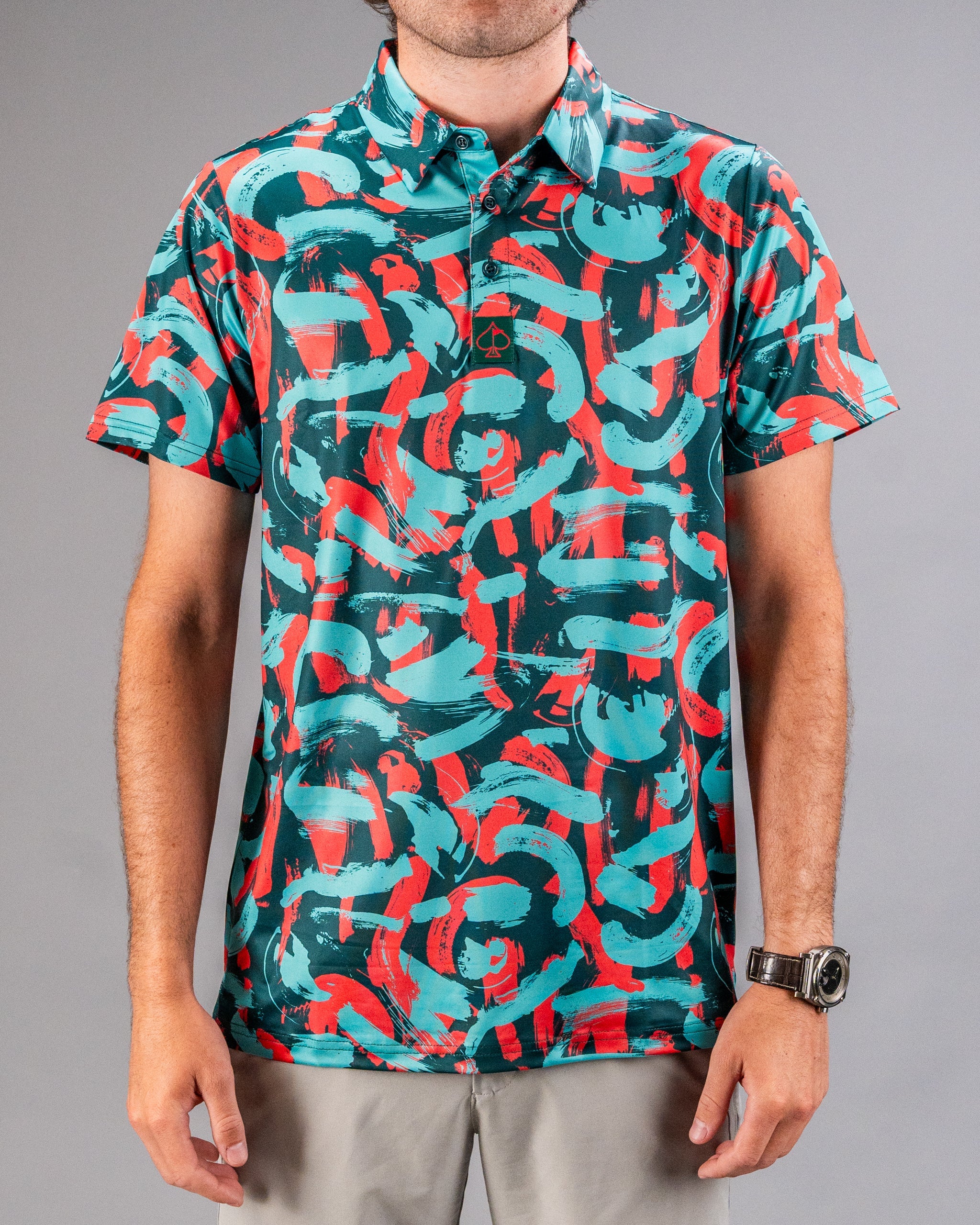 Men's golf polo featuring a vibrant coral and teal paint stroke pattern, perfect for making a bold statement on the course.