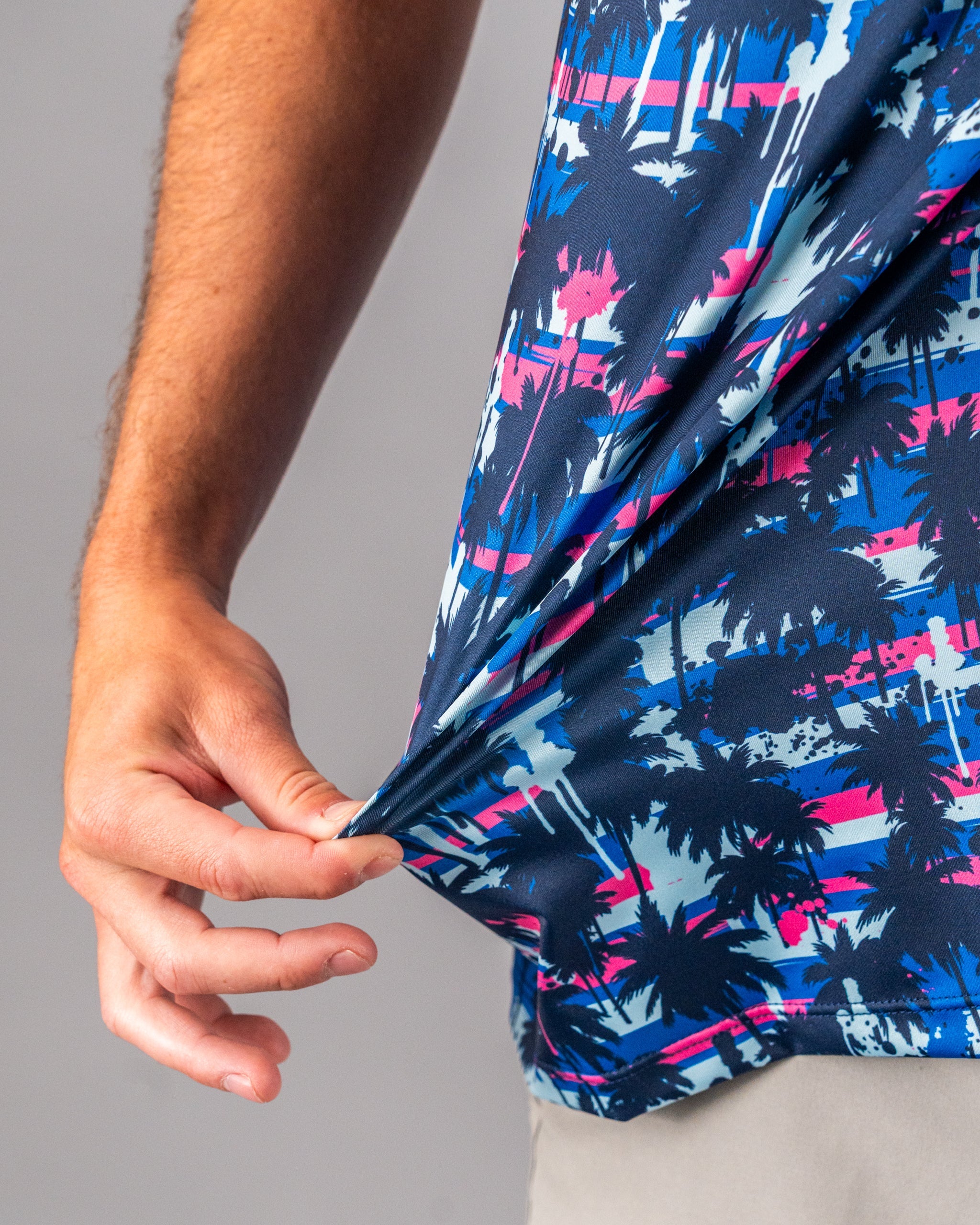 Bright blue, pink, and navy palm tree golf shirt with bold, tropical print for golfers who want to stand out.