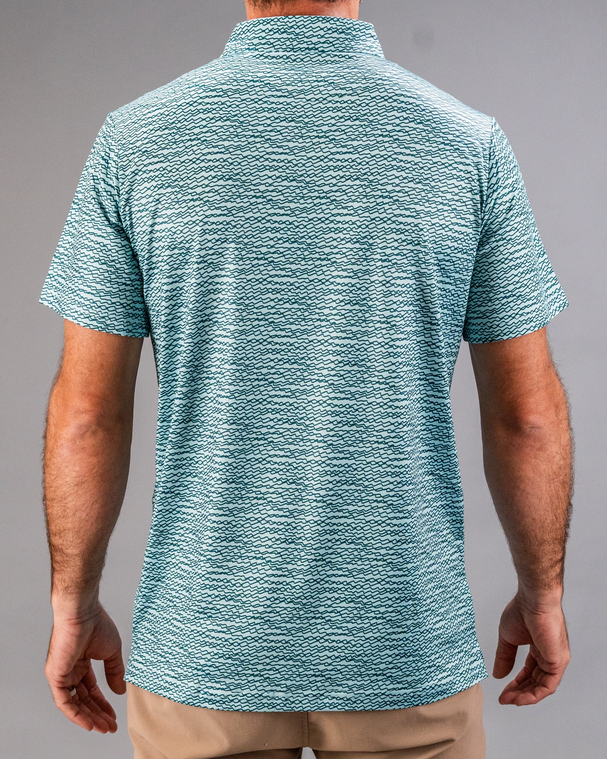 Men's teal golf shirt featuring a unique squiggle pattern, designed for style and comfort on the course.