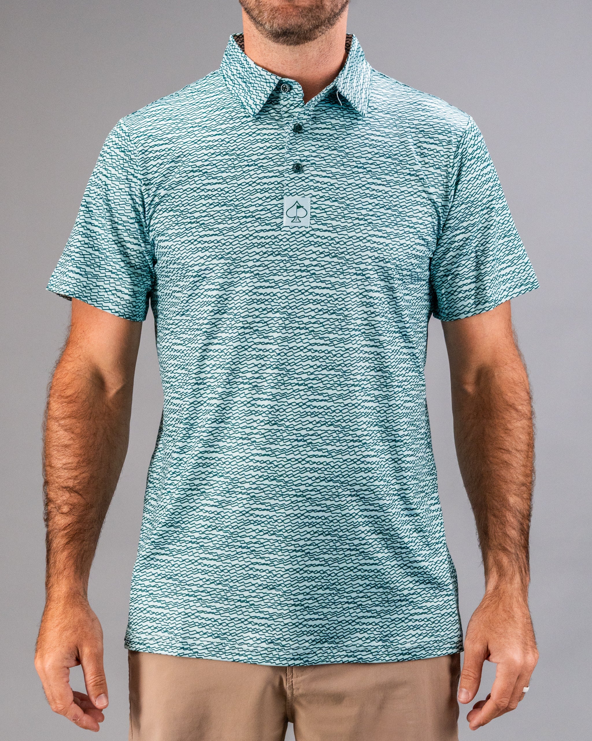 Men's short-sleeve golf shirt in teal with a squiggle pattern, featuring a collar and three-button placket.