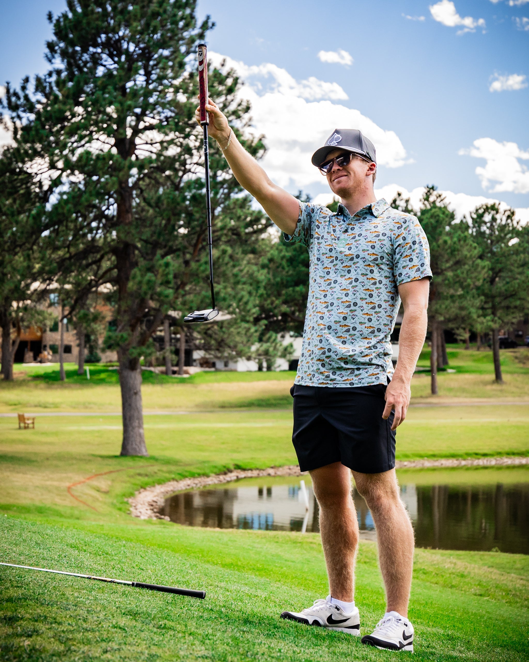 Collared polo shirt in autumn colors hanging on a wooden outdoor railing with a blurred natural background.