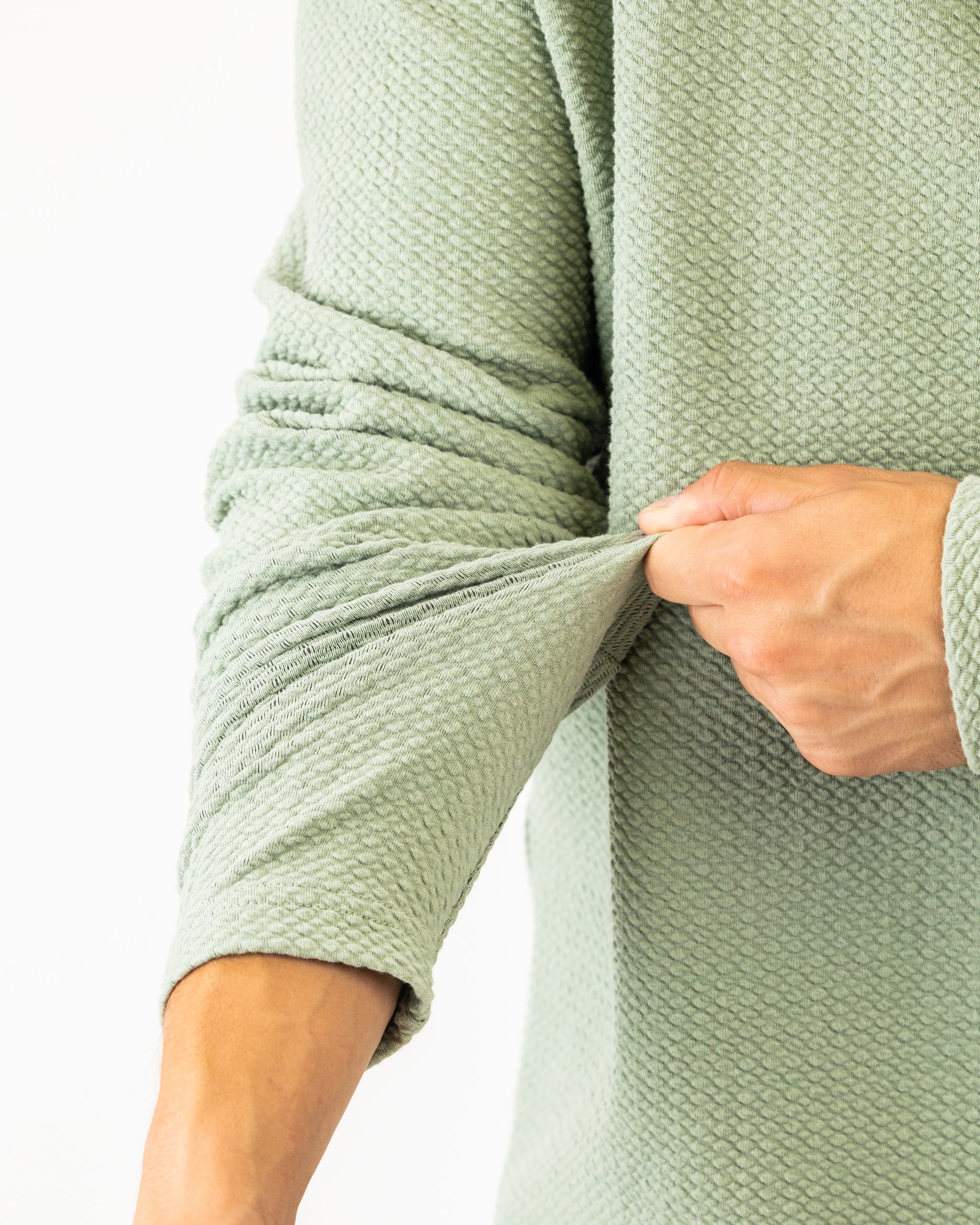 Olive green Player Preferred™ waffle knit pullover displayed on a wooden surface.