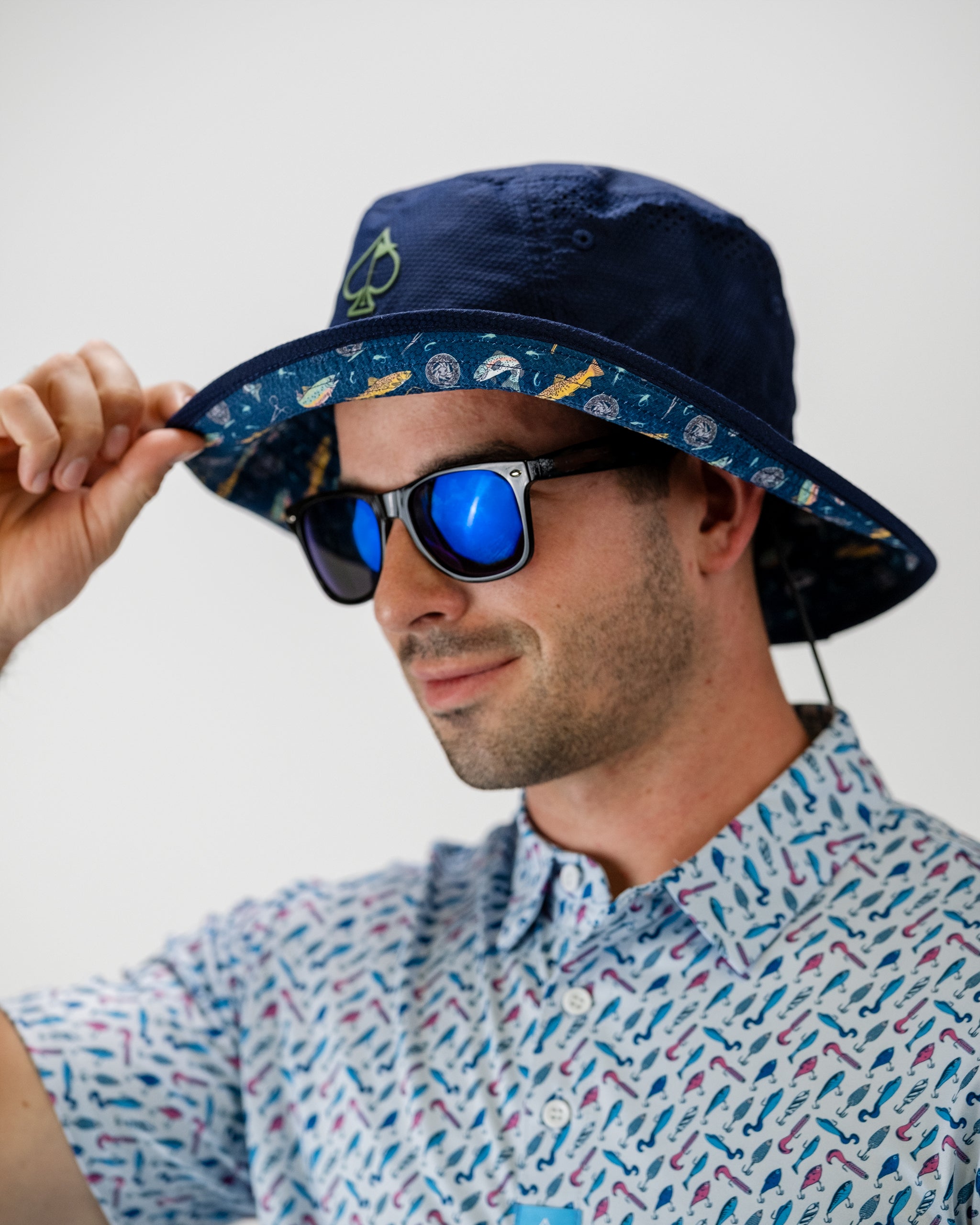 Bucket hat featuring a vibrant "Catch & Release" design, showcasing fishing-themed graphics on a light background.