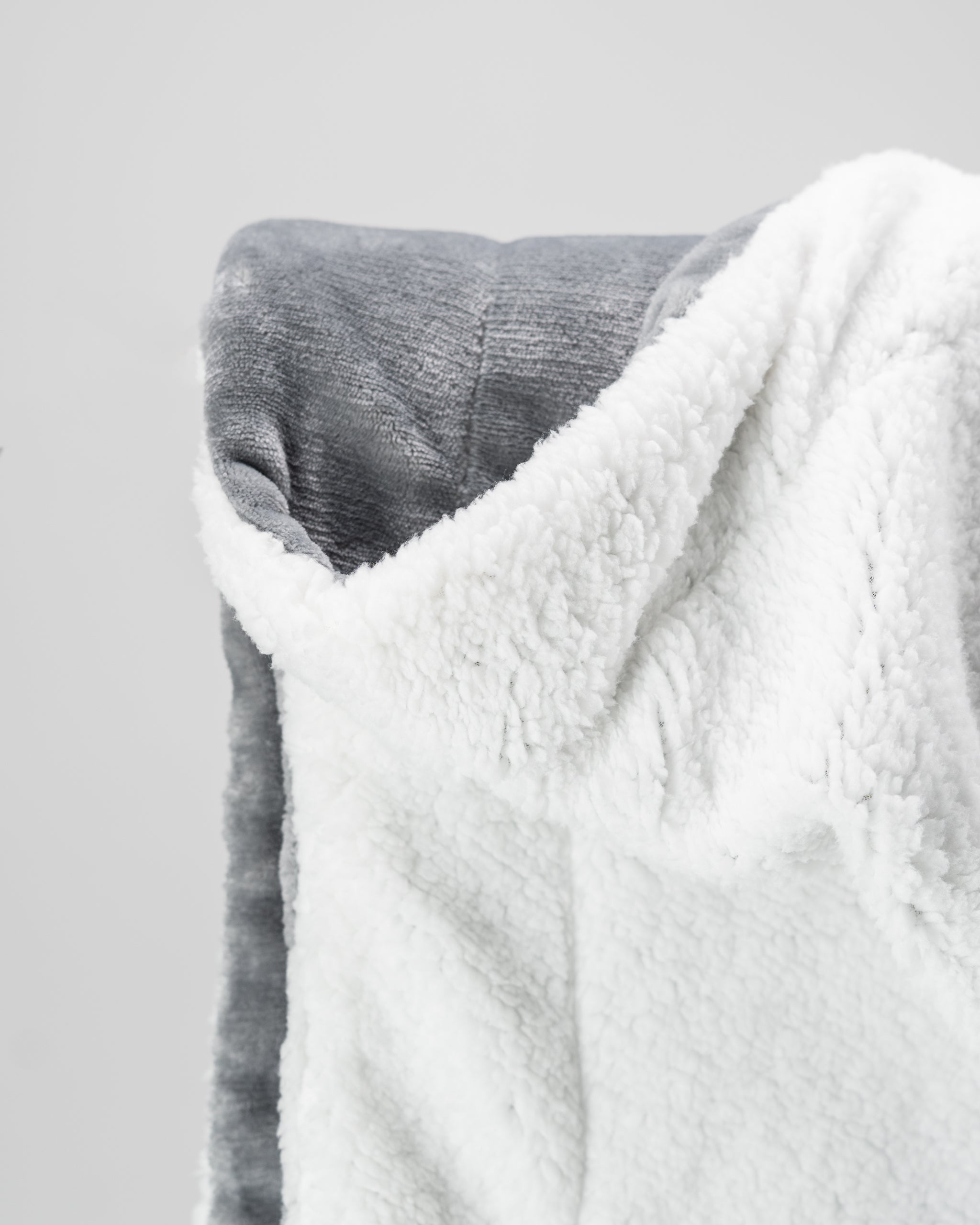 Light gray Bogey Blanket made from soft fleece, draped elegantly on a neutral background.