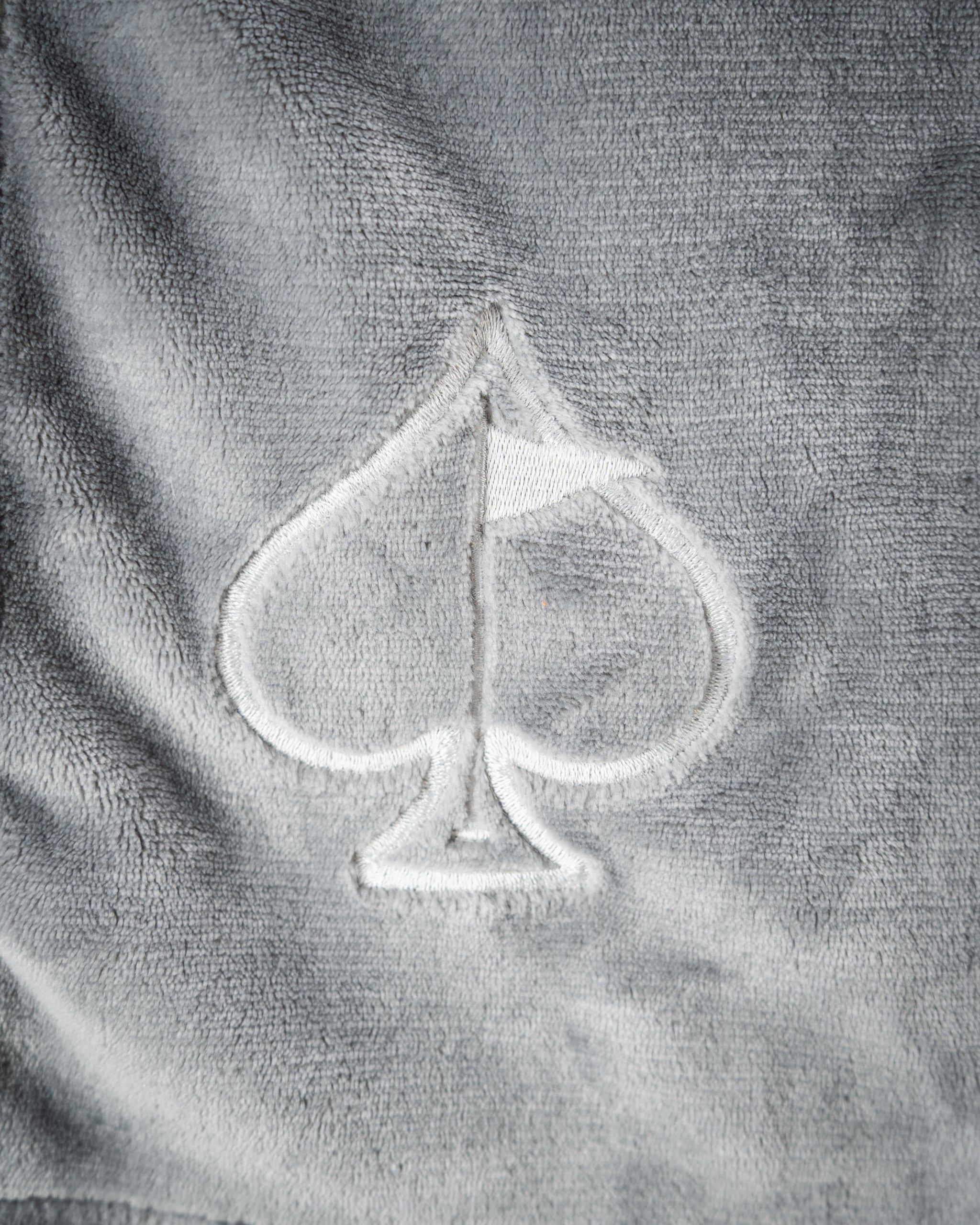 Light gray Bogey Blanket, featuring a soft, cozy fleece texture, draped elegantly.