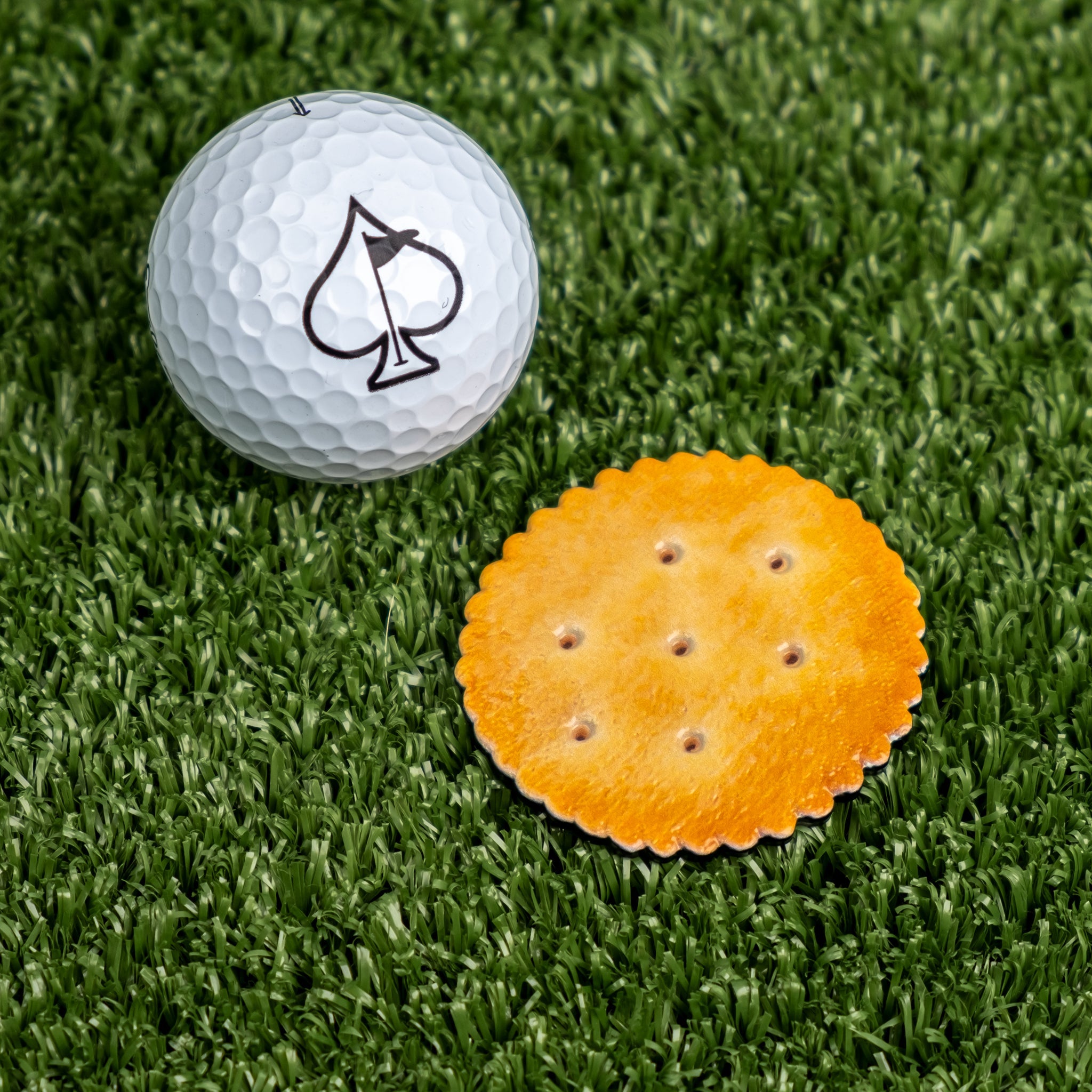 Gilmore Cracker ball marker featuring a detailed design inspired by the Happy Gilmore movie, positioned next to a golf ball.