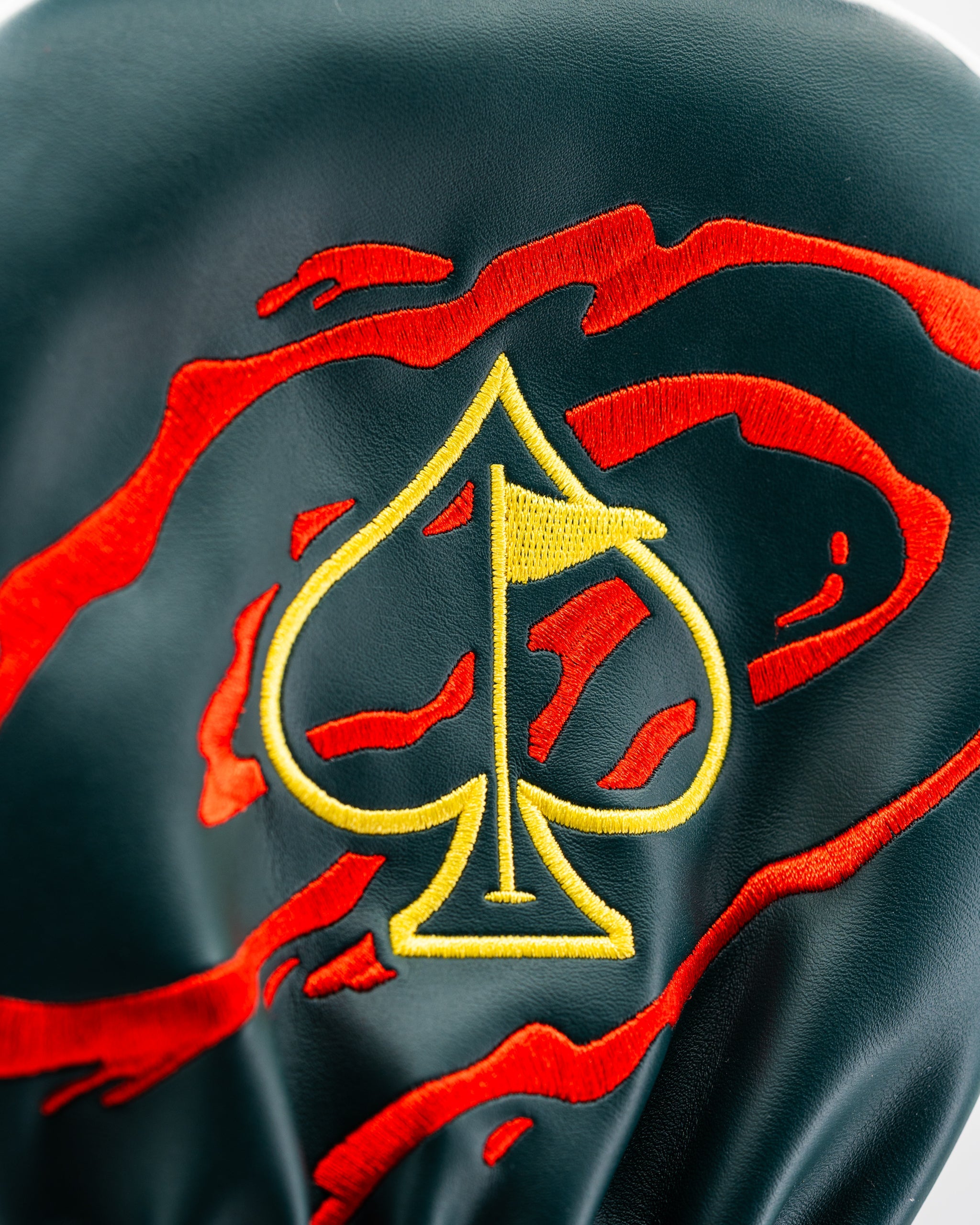 Bold driver cover featuring a vibrant red and black design with a prominent yellow spade emblem, perfect for stylish golfers.