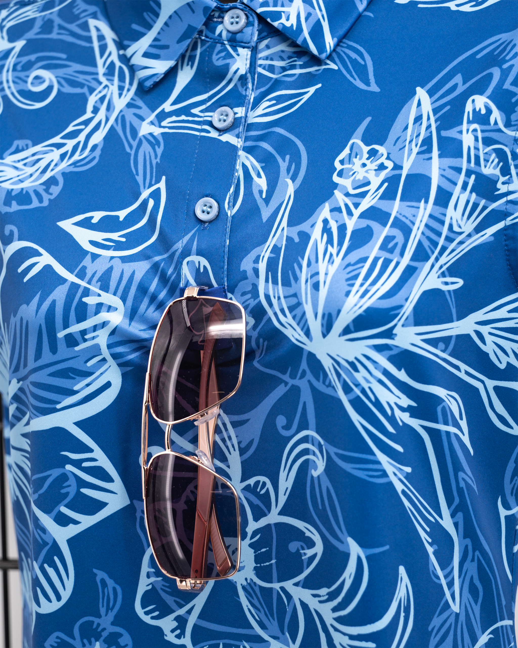 Women's Cabo Ocean polo shirt in vibrant blue, featuring a classic collar and short sleeves, displayed on a hanger.