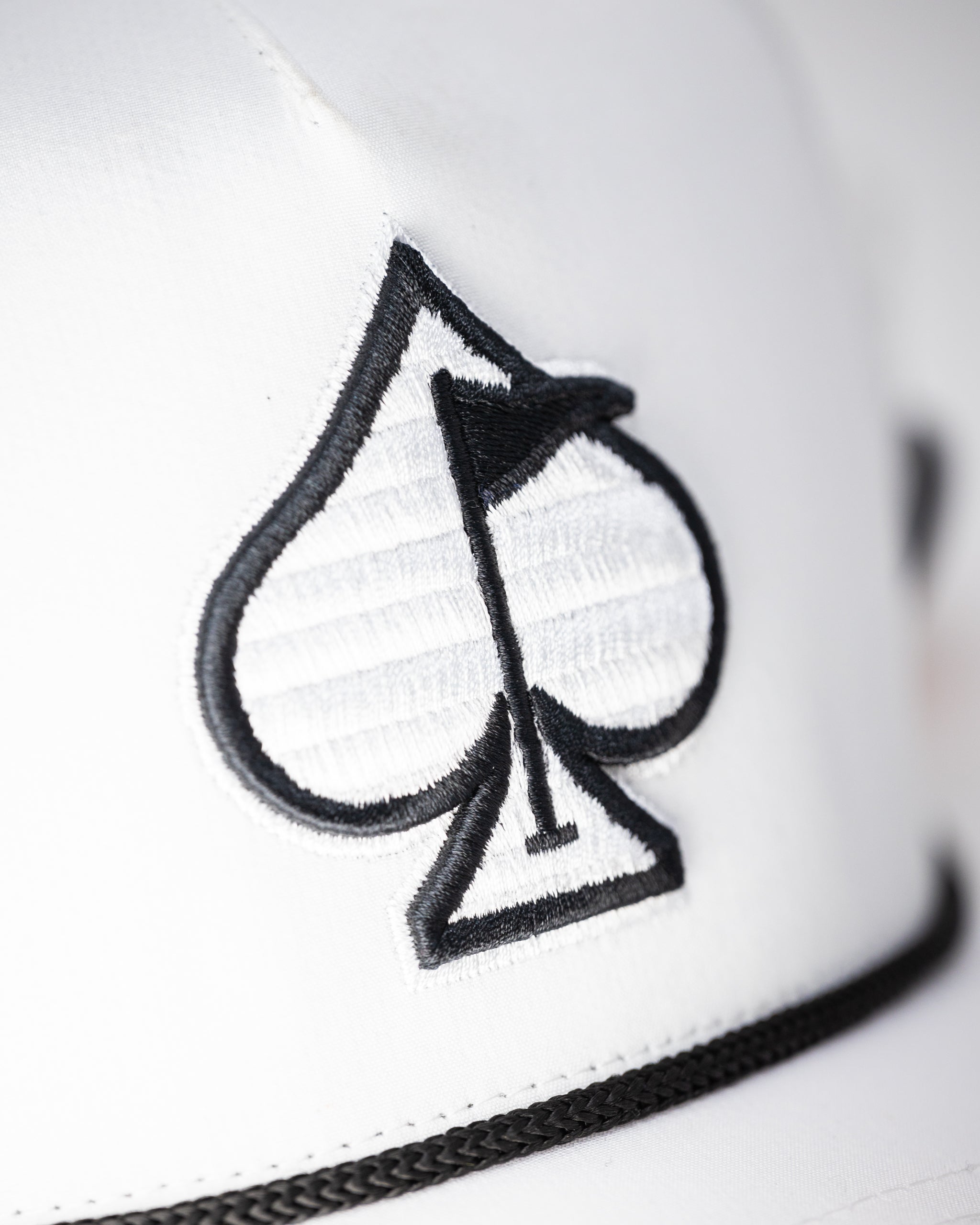 Perforated white rope hat with a wide brim and structured design, perfect for summer wear.