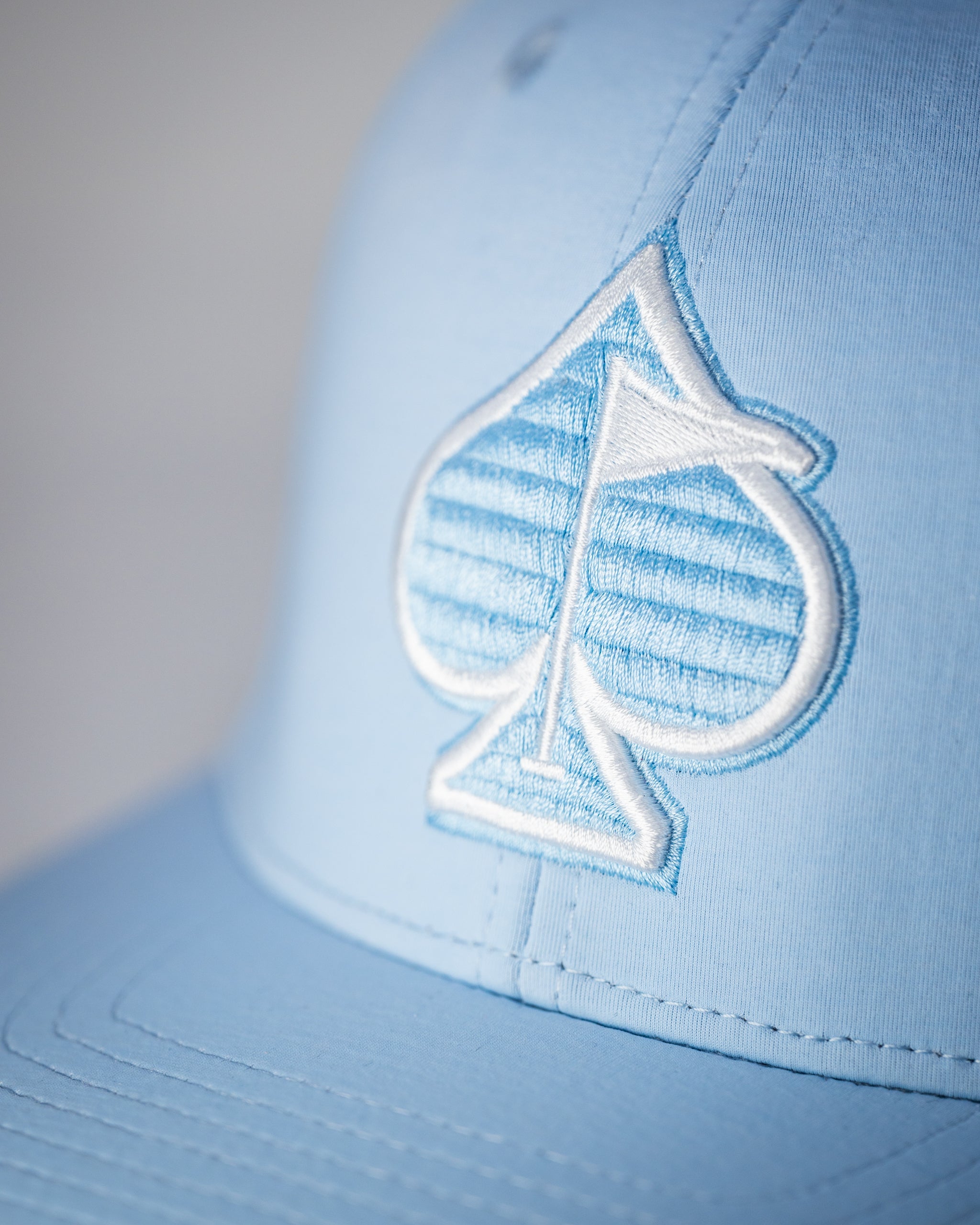 Performance Spade Hat in Carolina Blue featuring a breathable fabric and adjustable strap for a comfortable fit.