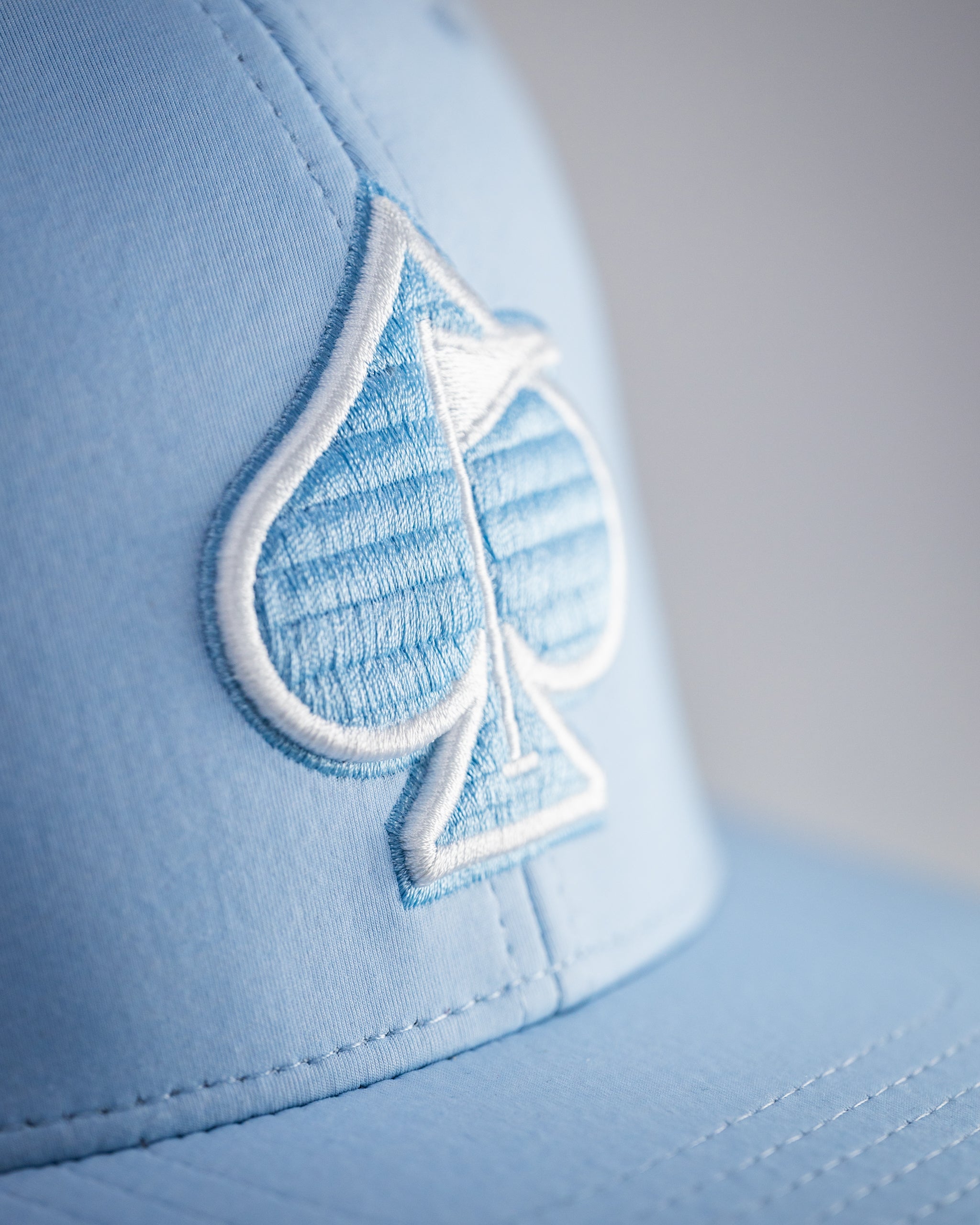 Performance Spade Hat in Carolina Blue featuring a breathable design and stylish logo.