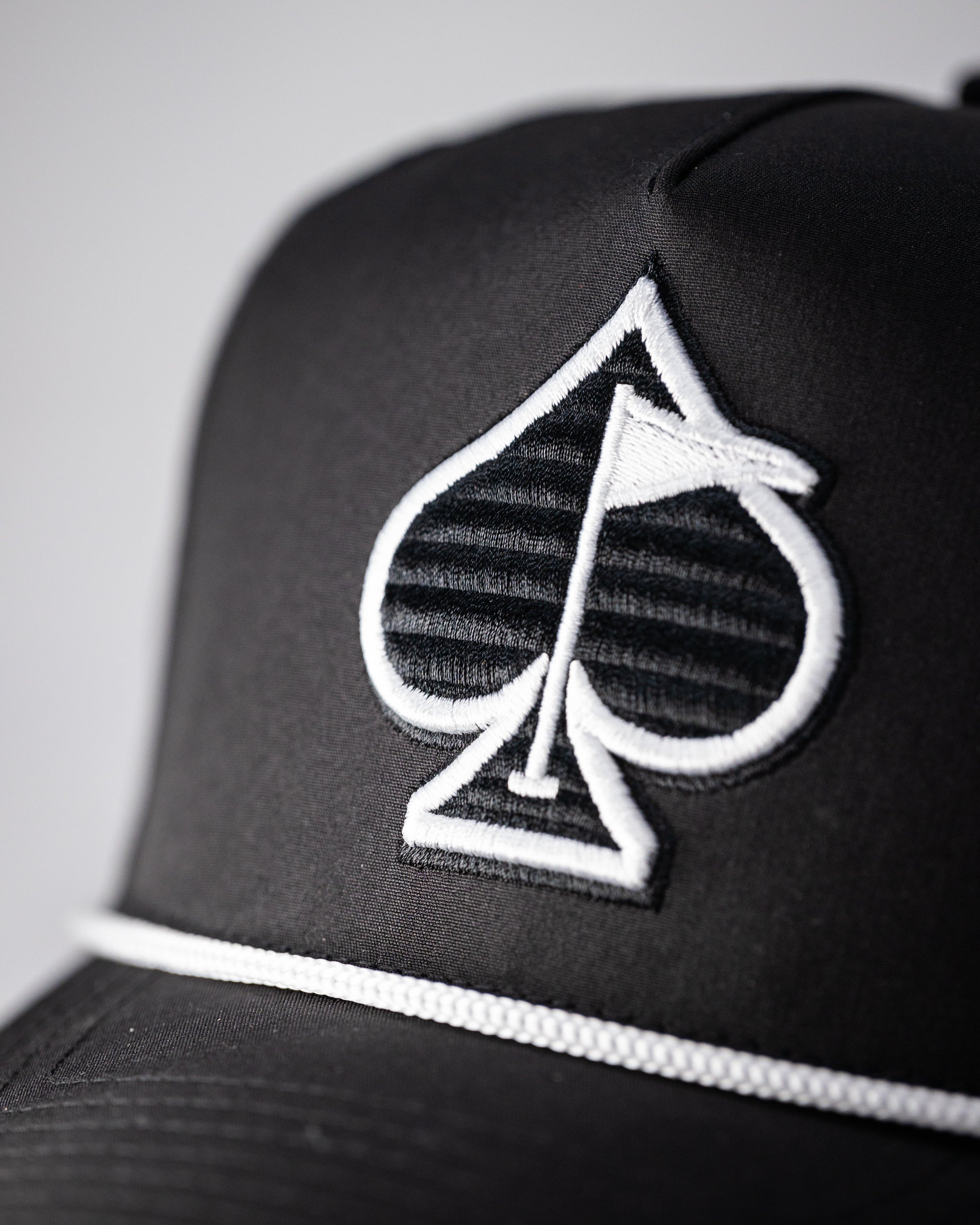 Black perforated rope hat featuring a trendy design and breathable material.