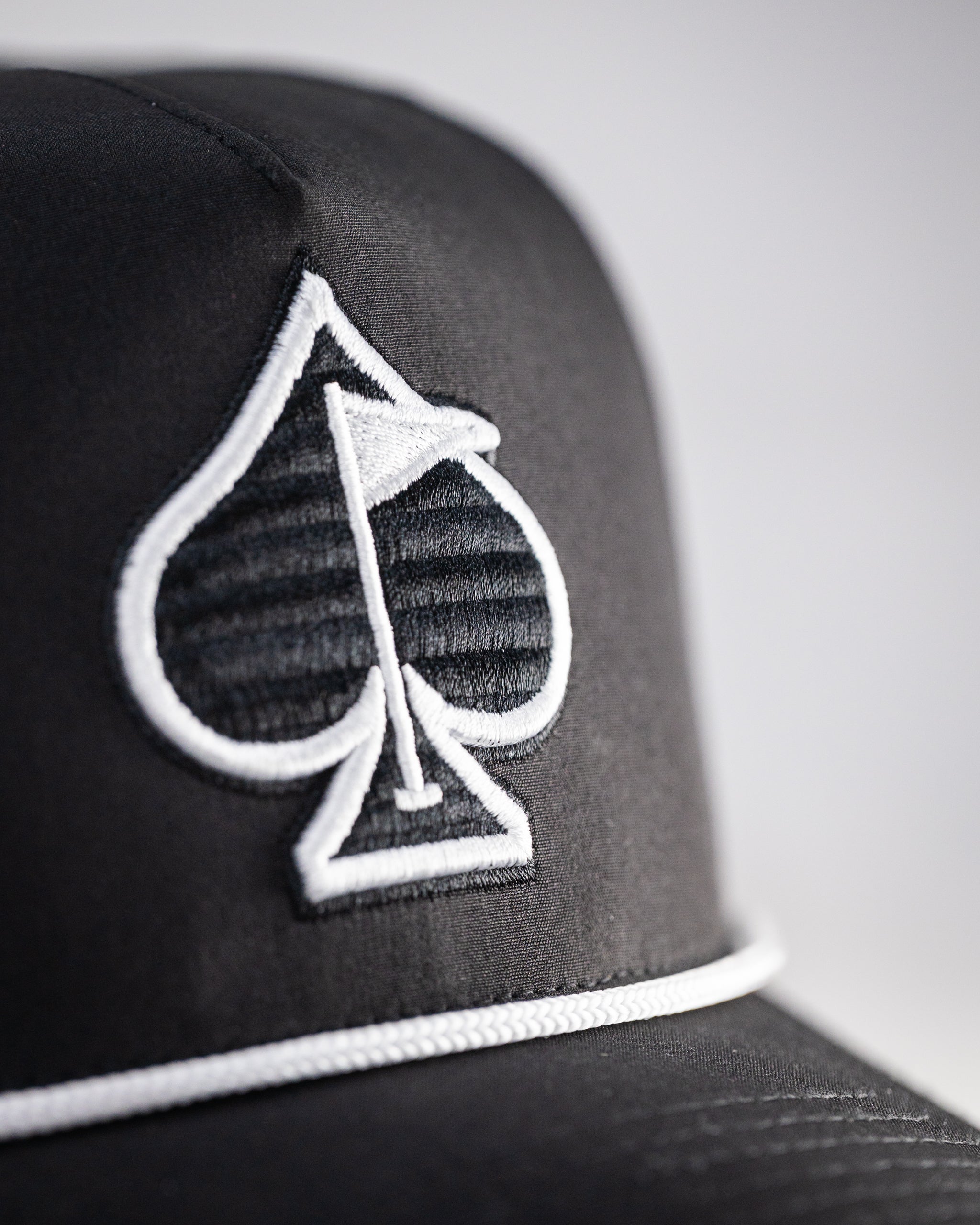 Perforated black rope hat with a stylish design and breathable material.