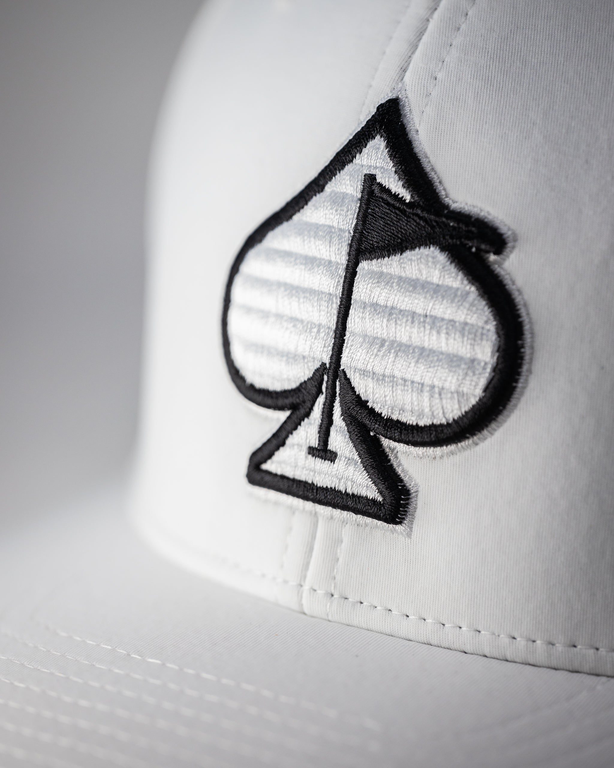 White Performance Spade Hat featuring a sleek design and breathable fabric, perfect for outdoor activities.