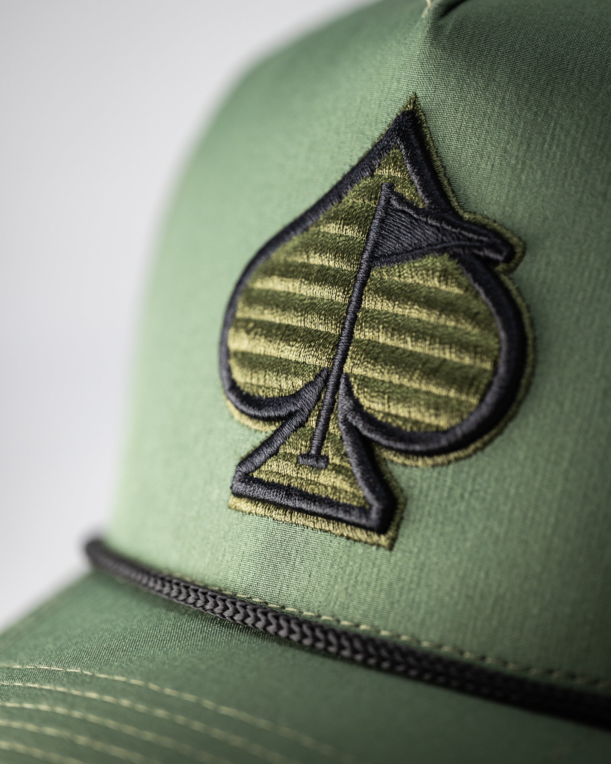 Perforated olive rope hat with a wide brim and adjustable chin strap.