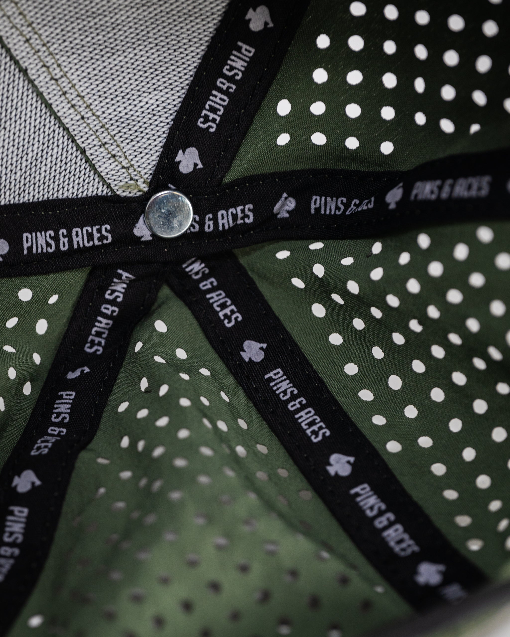 Perforated olive green rope hat displayed on a neutral background.