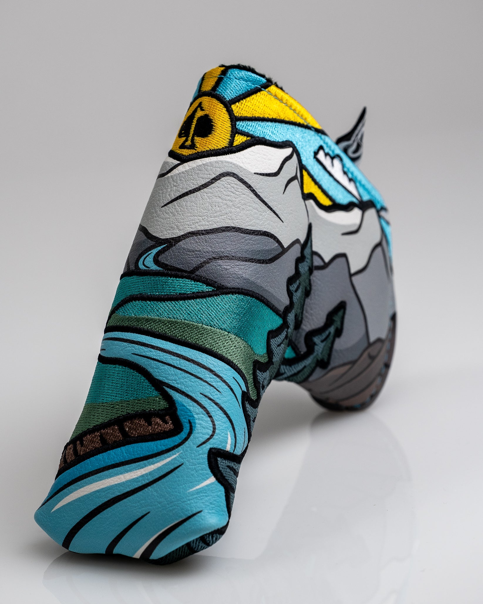 Colorful embroidered golf headcover featuring mountains, river, and sun design, perfect for bold, unique golf accessories.