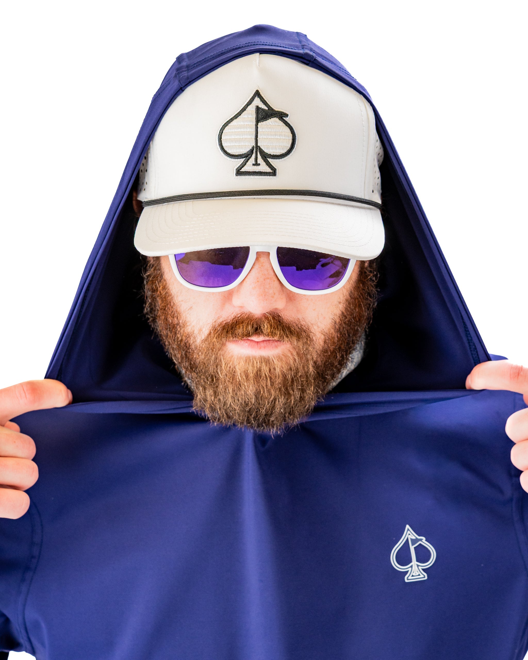 Navy performance golf hoodie worn by a man adjusting the hood, featuring a logo and stylish sunglasses.
