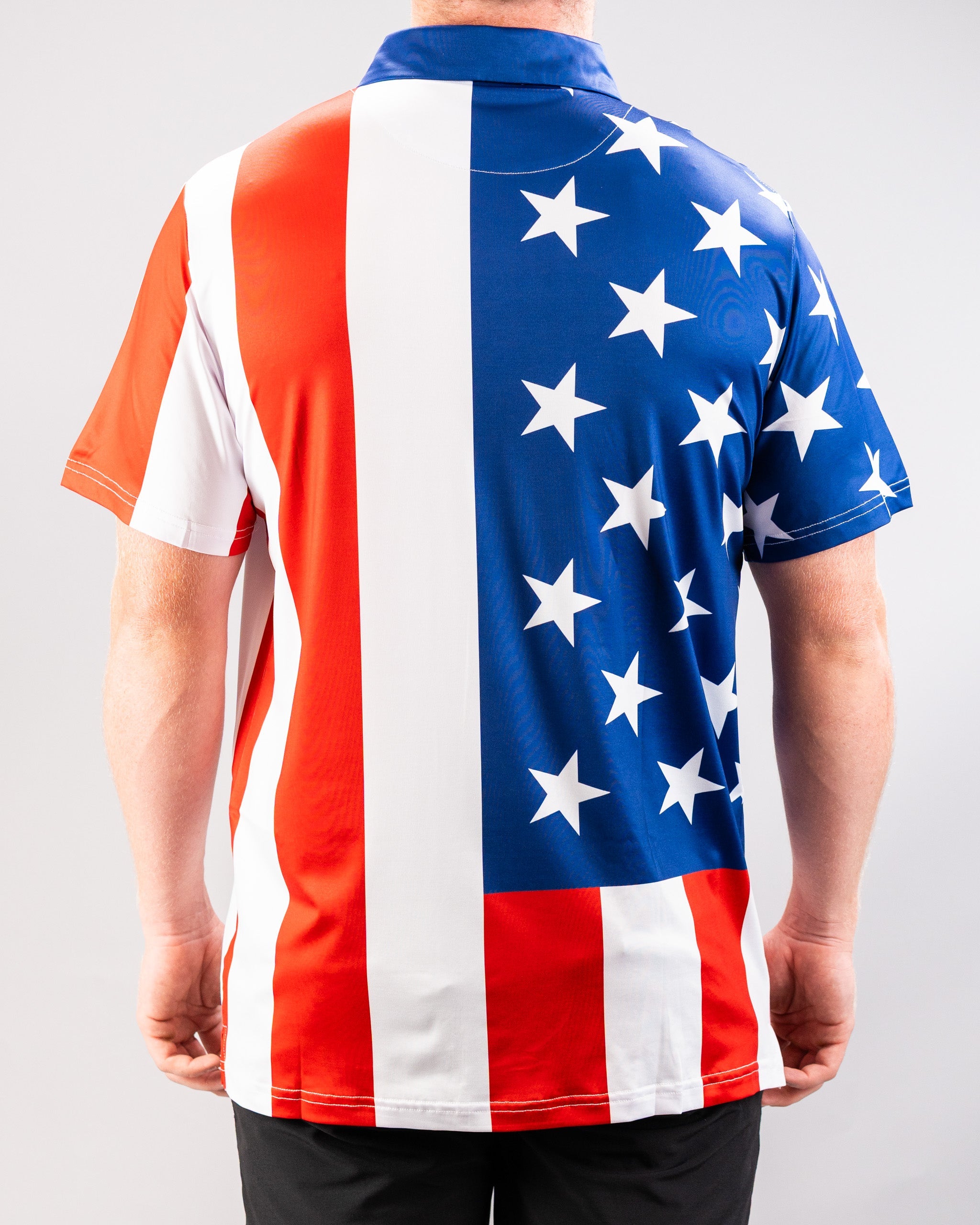 A person wearing a short-sleeved shirt featuring a design inspired by the American flag, with red and white stripes and a blue field with white stars.