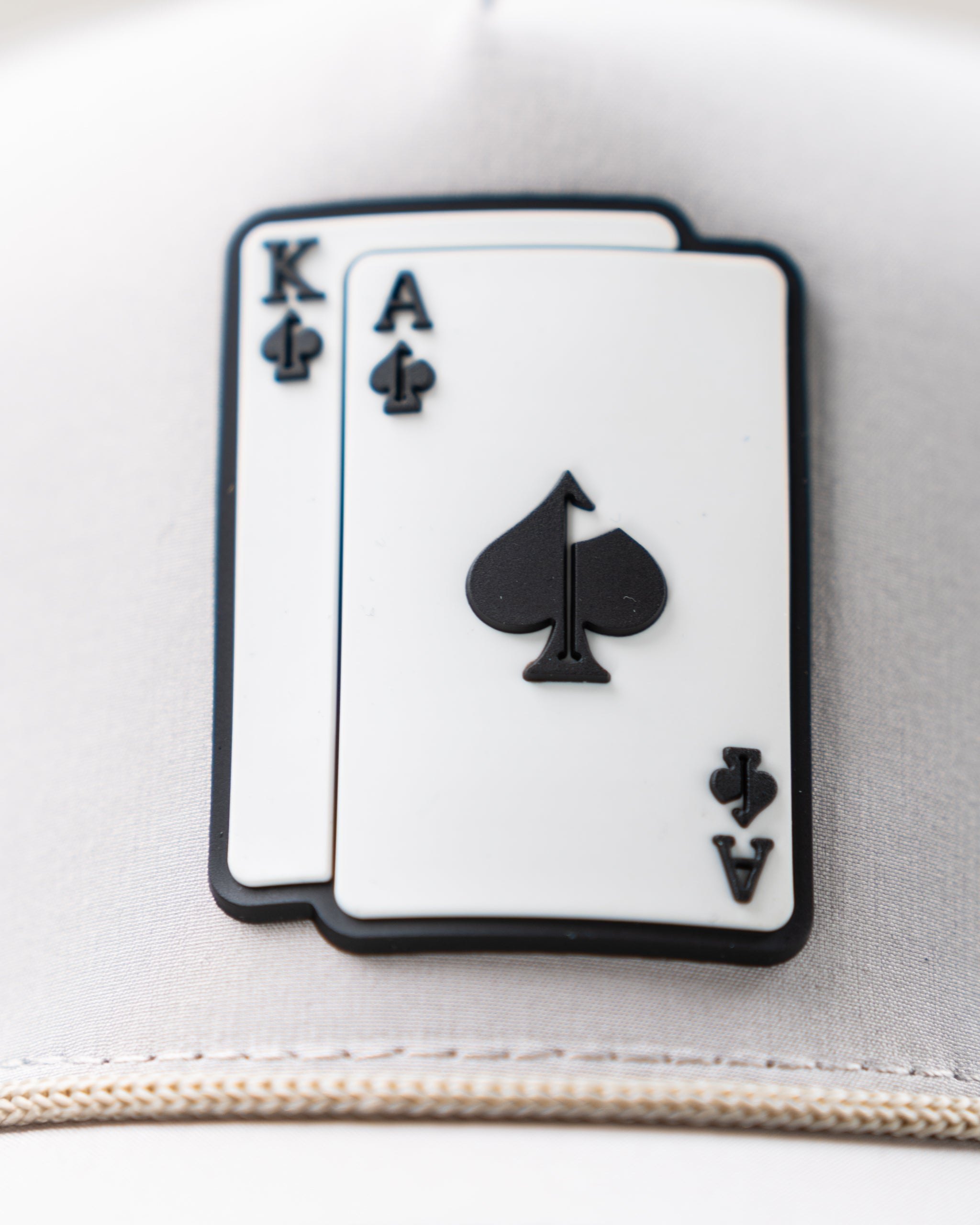 Perforated Rope Hat in Bone color with "AK" logo, featuring a stylish design and adjustable strap.