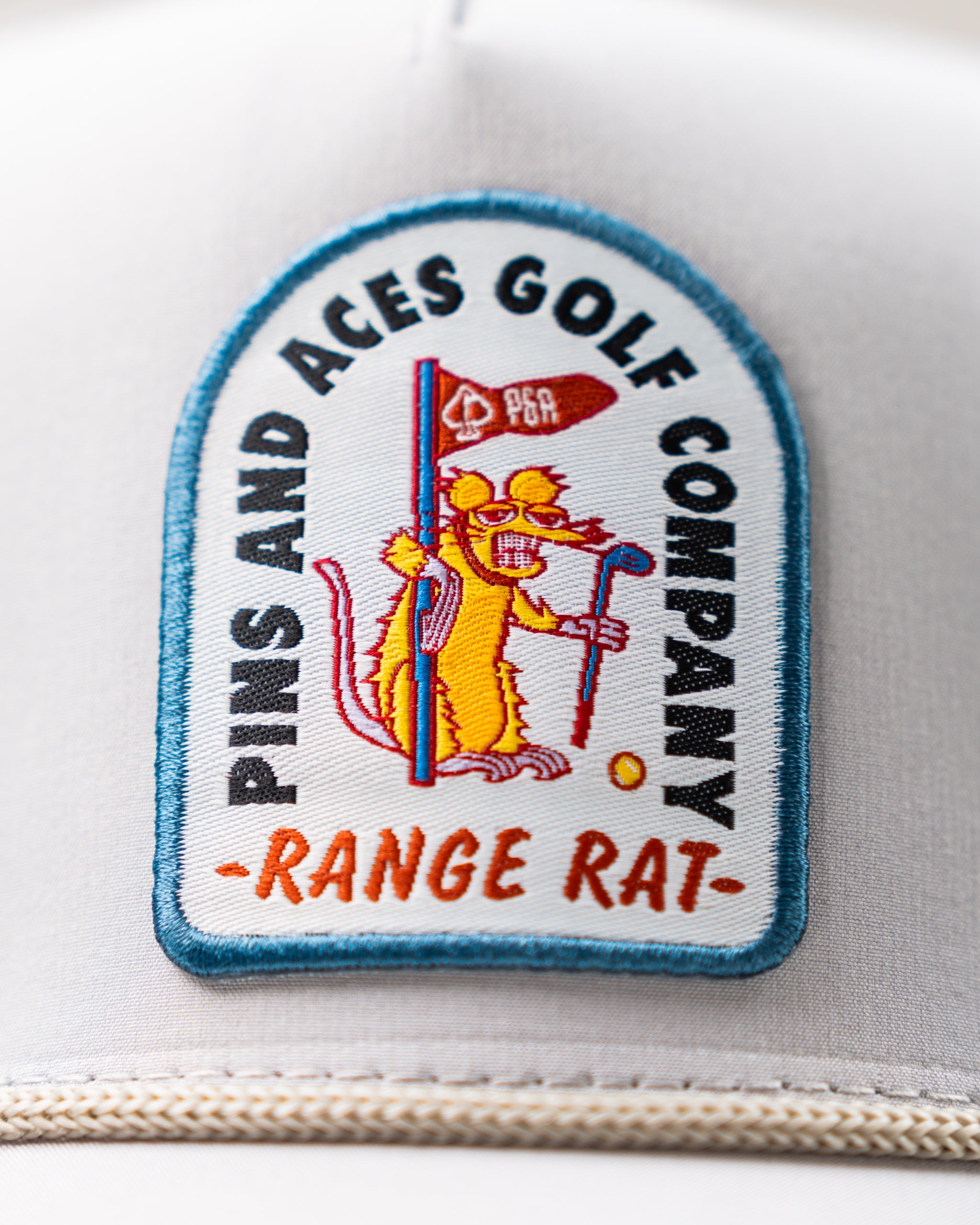 Perforated Rope Hat in Bone color with Range Rat logo, featuring a stylish design and adjustable fit.