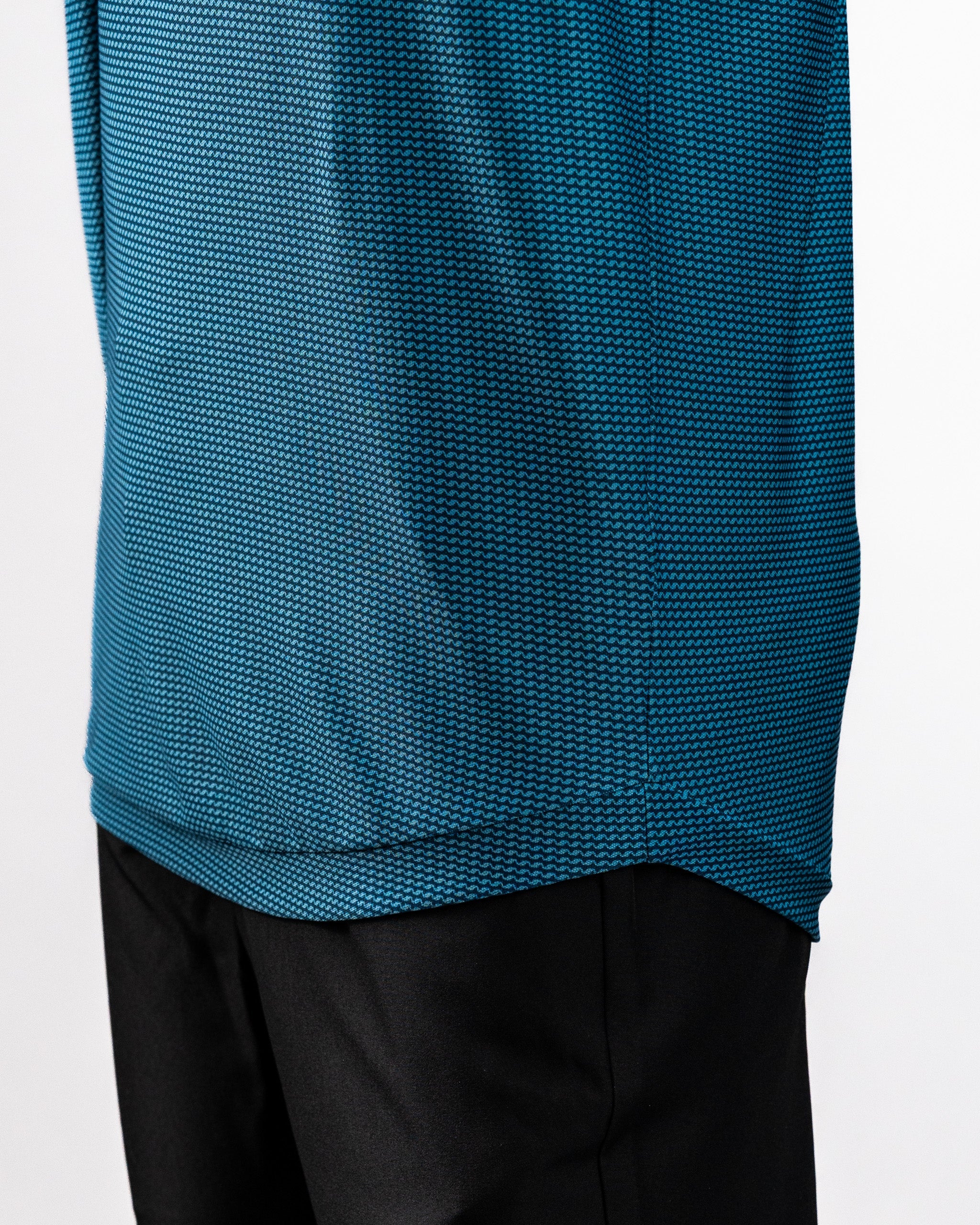 Close-up of a blue Player Preferred™ Polo shirt with a wave pattern, paired with black pants.