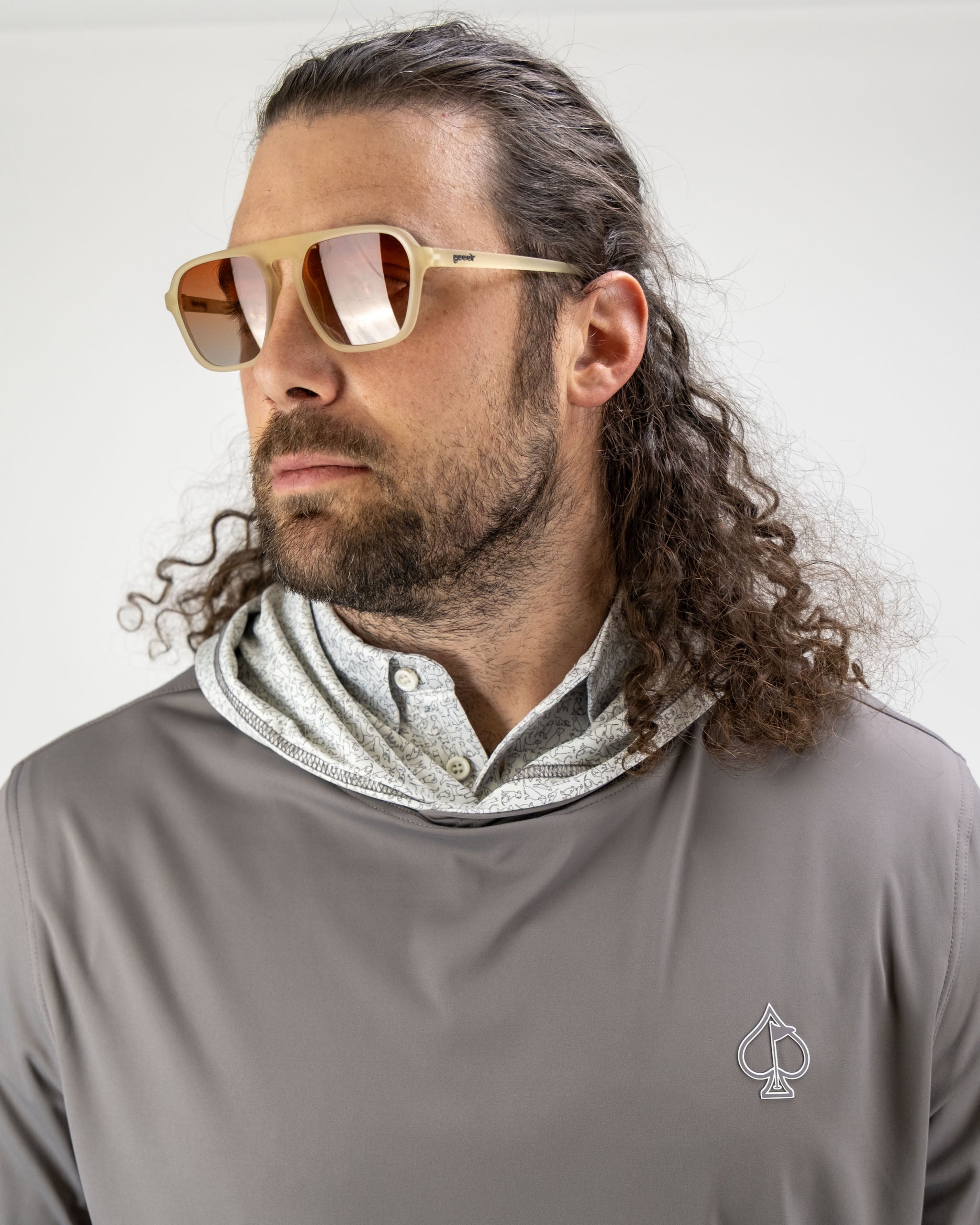 Man wearing a Performance Golf Hoodie with a gray exterior and a light hood, paired with stylish sunglasses.