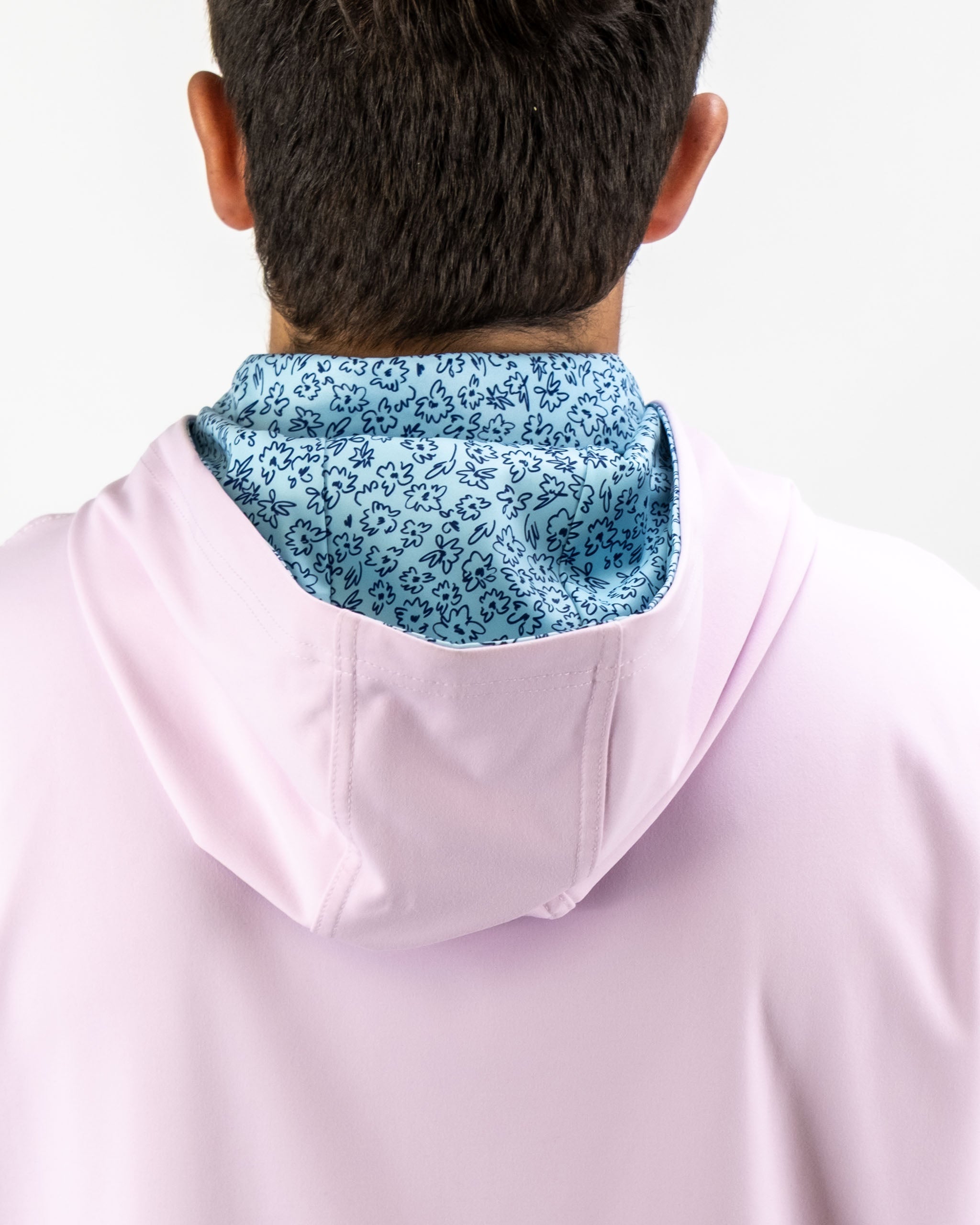 Men's performance golf hoodie in light pink with a blue flower doodle interior lining, designed for comfort on the course.