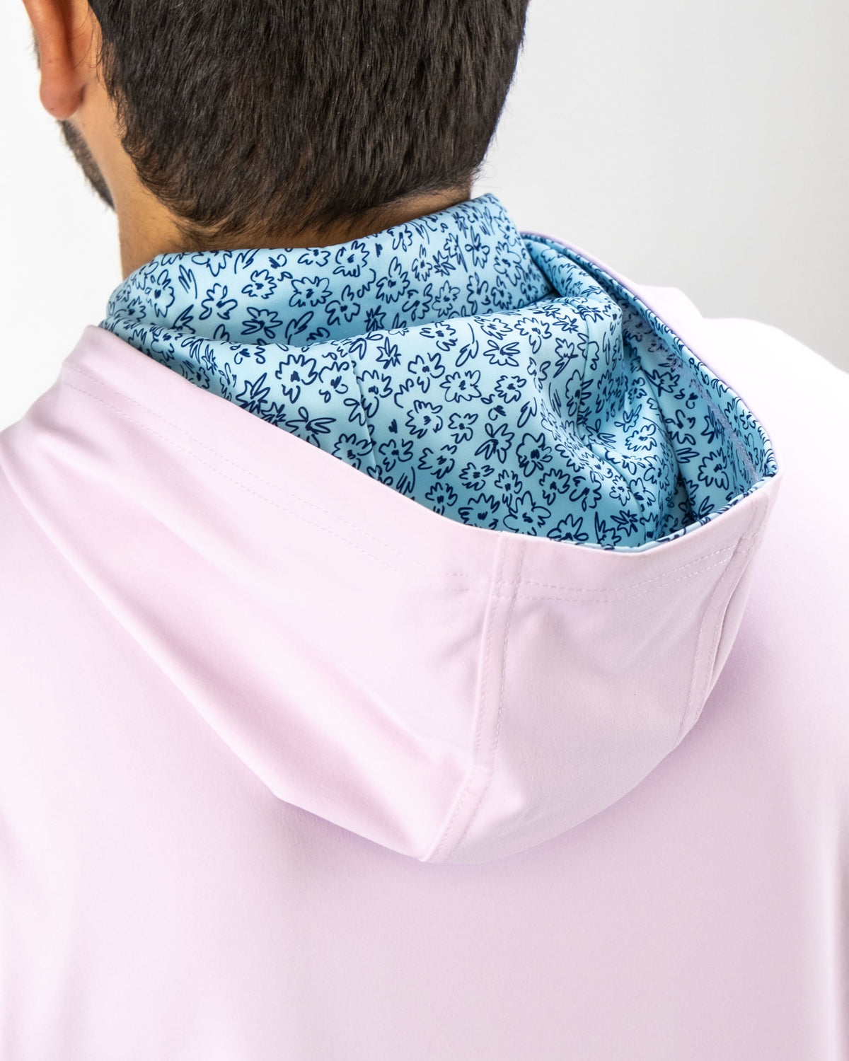 Light pink performance golf hoodie featuring a blue flower doodle pattern on the interior of the hood.