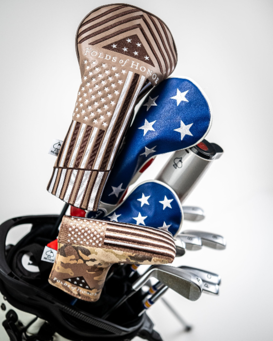 Folds of Honor 2.0 blade putter cover featuring patriotic designs, displayed on golf clubs in a bag.