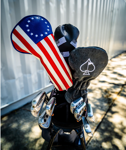 Betsy Ross driver cover featuring a patriotic flag design, alongside a sleek black headcover with an ace symbol.