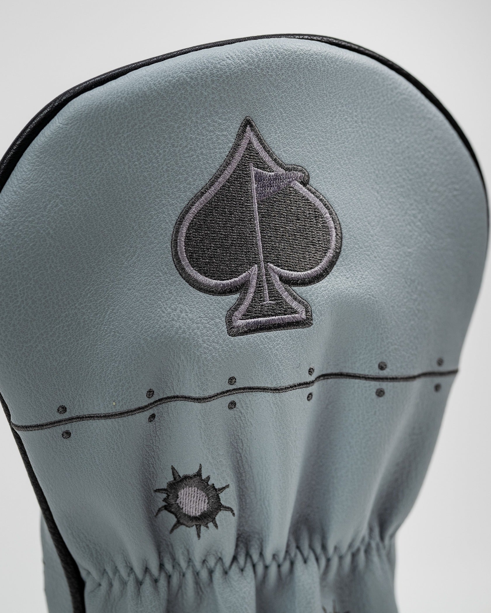 Stylish gray driver cover featuring an embroidered spade design, perfect for golfers seeking unique accessories.