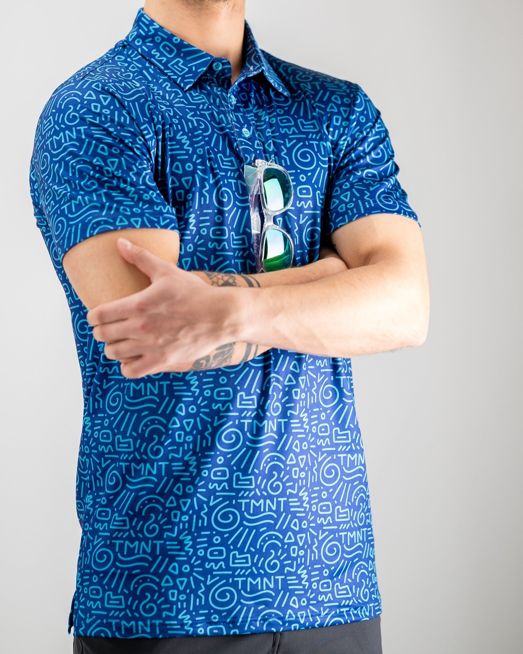 Men's blue golf polo featuring a playful TMNT doodle pattern, perfect for stylish golfers who want to stand out.