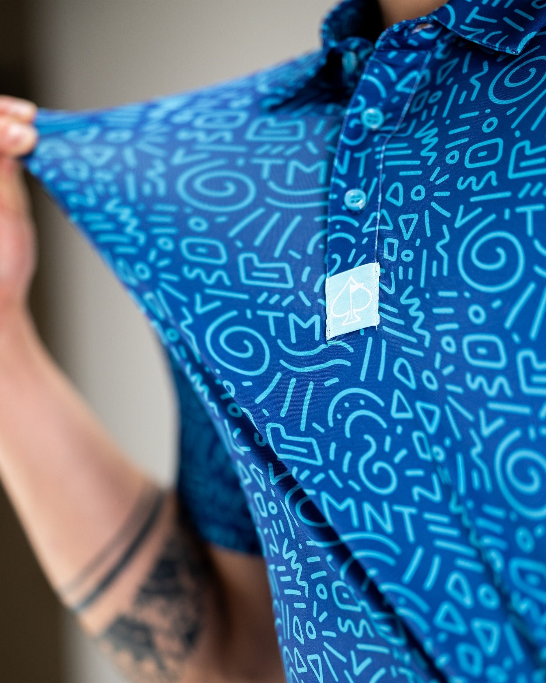 Bold blue polo shirt featuring a playful doodle pattern inspired by TMNT, showcasing unique style for golfers.
