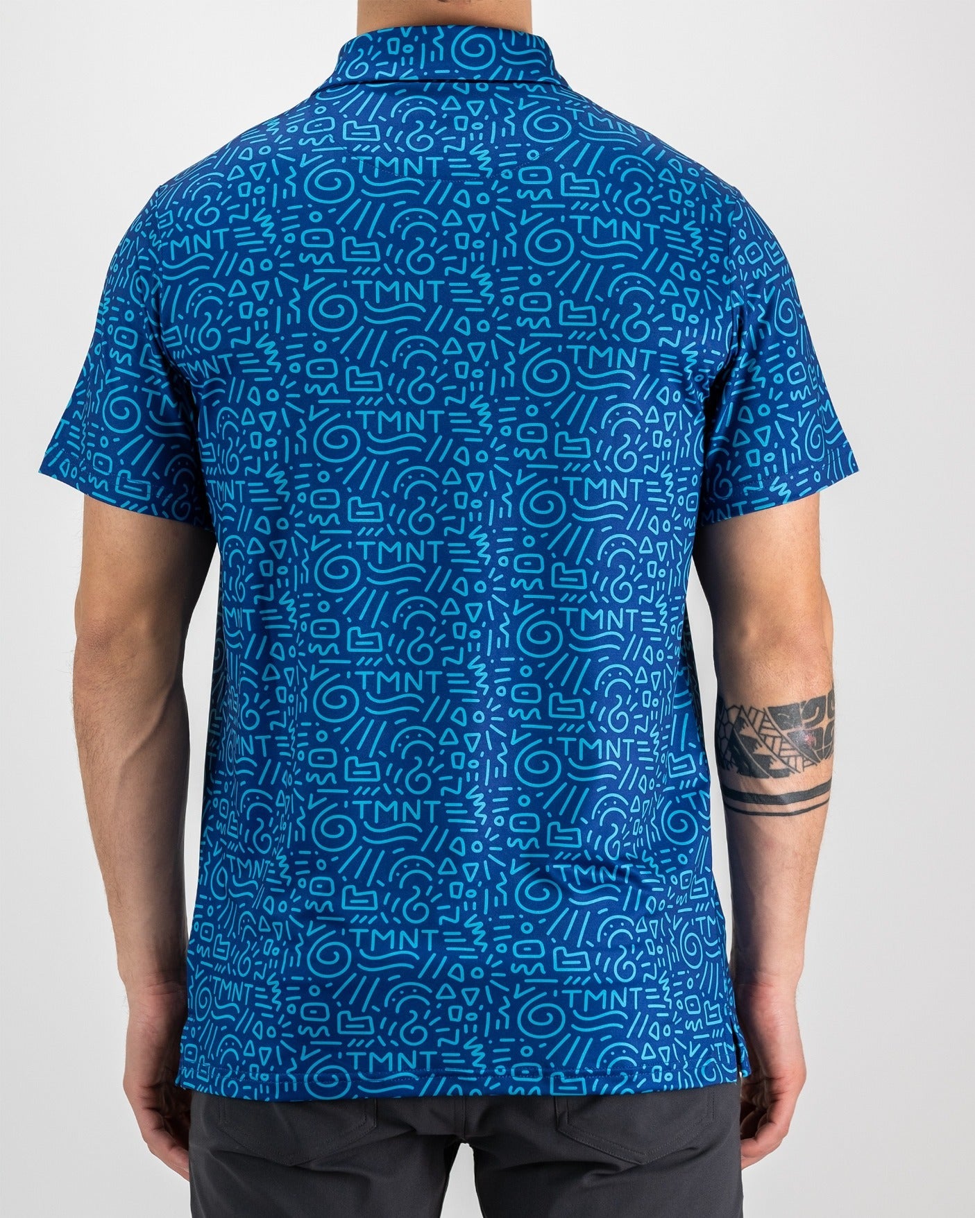 Men's blue short-sleeve shirt featuring a playful TMNT doodle pattern, perfect for casual outings or golf.