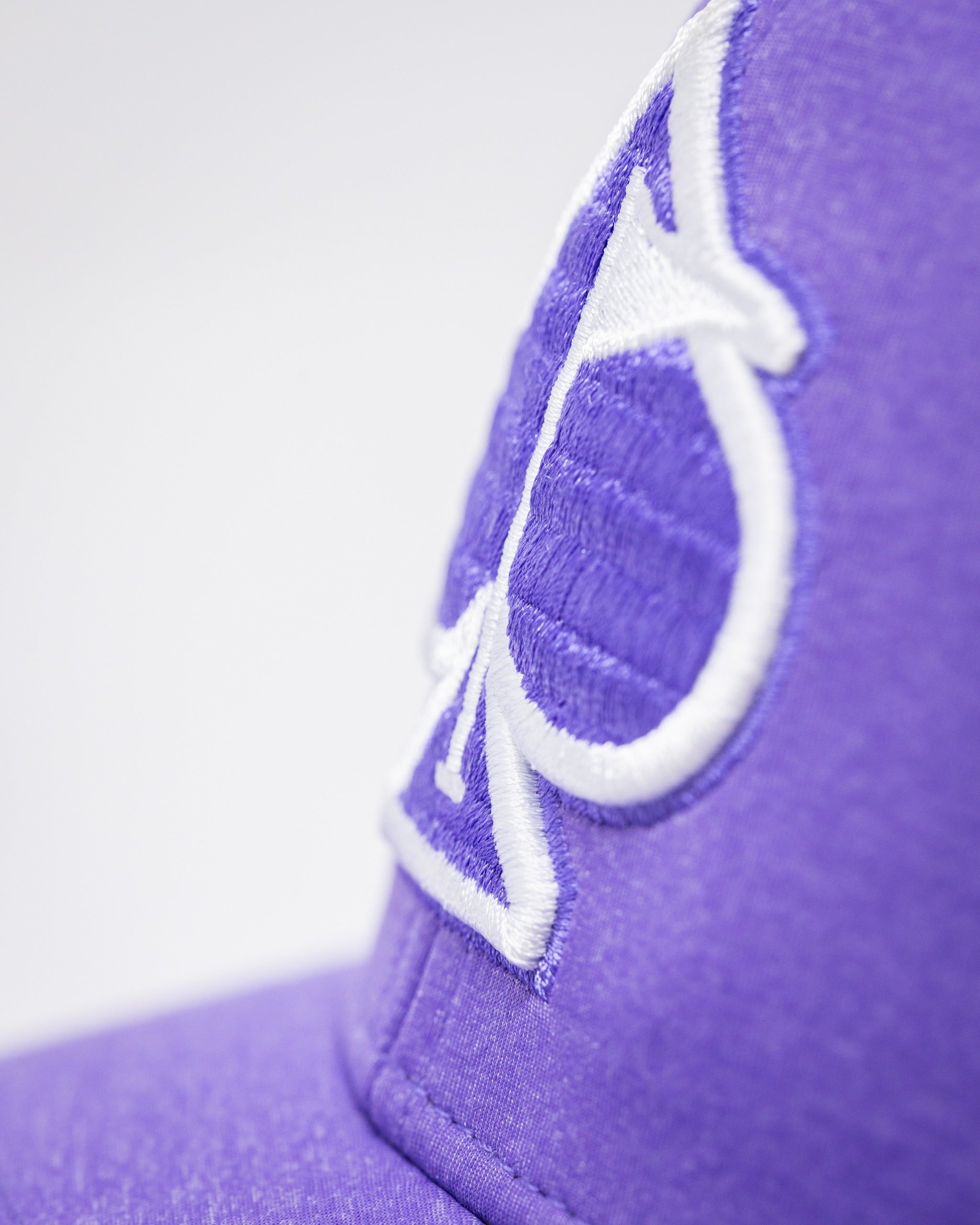 Lavender Performance Spade Hat featuring a bold embroidered spade logo, perfect for stylish golfers on the course.