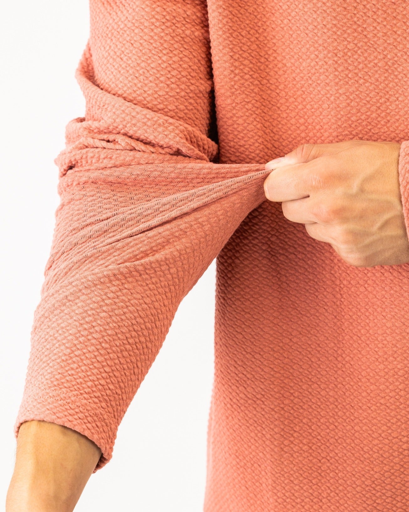 Terracotta waffle knit pullover showcasing a close-up of the textured fabric and sleeve detail. Ideal for stylish golfers.